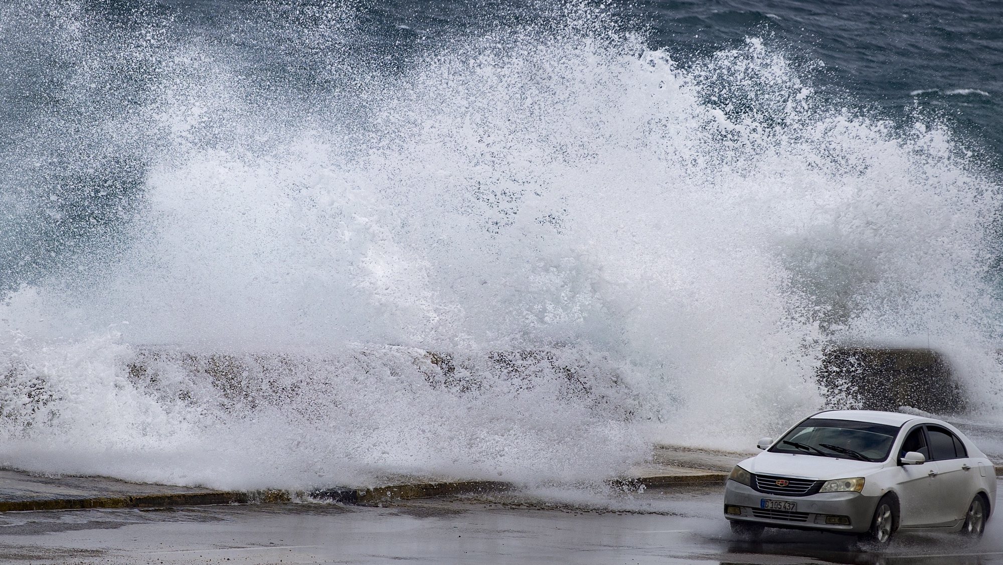 epa10296528 A car drives past heavy waves caused by tropical storm Nicole, in Havana, Cuba, 09 November 2022.  EPA/YANDER ZAMORA