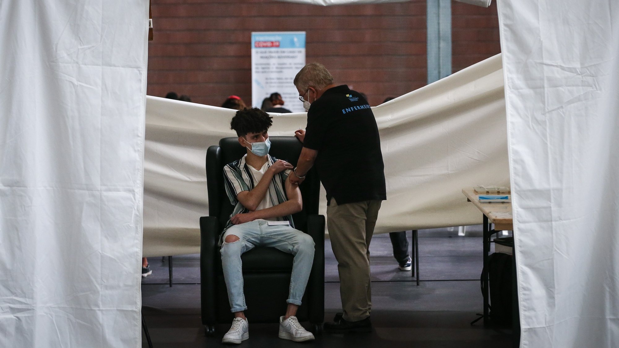 Um adolescente é vacinado contra o Covid-19 durante o fim de semana de vacinação de jovens de 16 e 17 anos, no Pavilhão António Feliciano Bastos, em Loures , 14 de agosto de 2021.  RODRIGO ANTUNES/LUSA