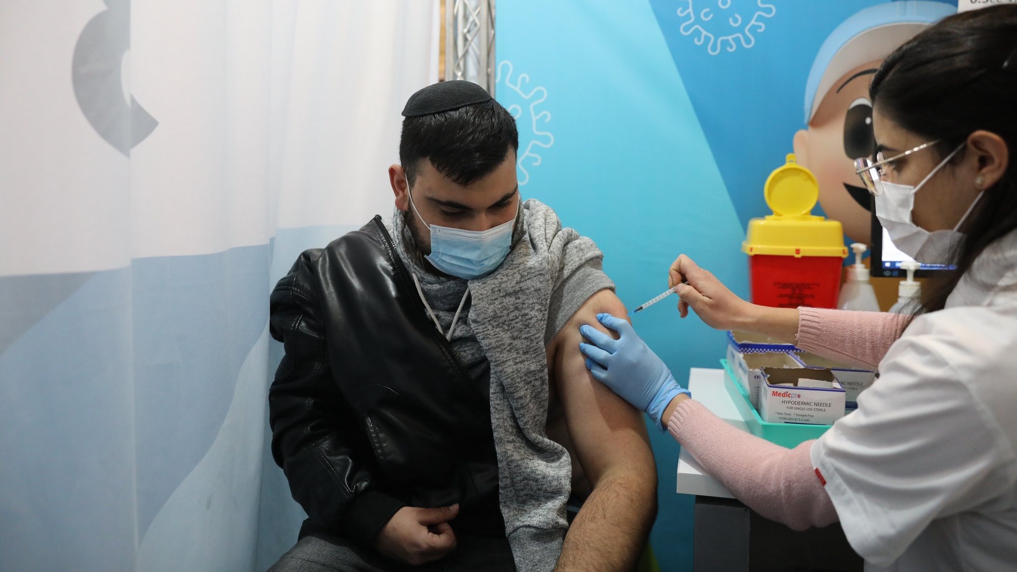 epa09653717 A nurse injects a man with a shot of COVID-19 vaccine in Jerusalem, Israel, 22 December 2021. Israel will approve a 4th dose of covid-19 vaccine campaign due to the Omicron variant spread fear.  EPA/ABIR SULTAN