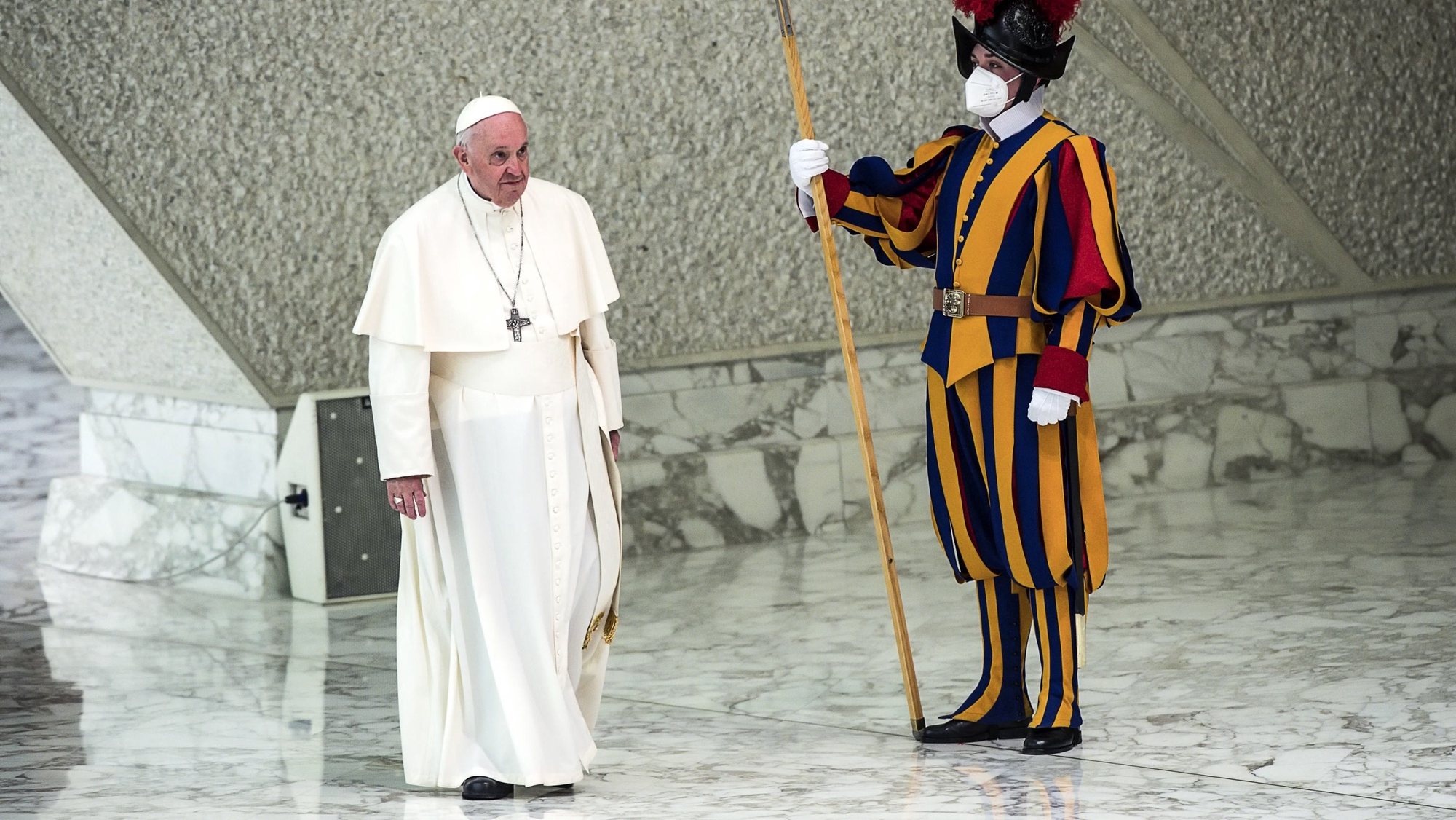epa09918210 Pope Francis (L) walks past a member of the Pontifical Swiss Guard as he arrives for an audience with participants in the pilgrimage from Slovakia in the Paul VI Audience Hall, in Vatican City, 30 April 2022.  EPA/ANGELO CARCONI