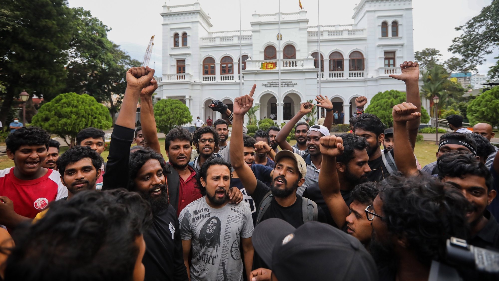 epa10071033 Protesters cheer and shout slogans after they vacate the Prime Minister&#039;s office in Colombo, Sri Lanka, 14 July 2022. after the resignation of Gotabaya Rajapaksa from the presidency was sent to the parliament speaker. Thousands of protesters broke through police barricades and stormed in to the President Palace, President office, Prime Minister&#039;s Residency and Prime Minister&#039;s office on 09 July. Meanwhile, Sri Lankan authorities declared a state of emergency and imposed a curfew in the Western Province of the country on 13 July.  Sri Lankan President Gotabaya Rajapaksa has authorised the prime minister Prime Minister Ranil Wickremesinghe to carry out presidential duties after the president fled to the Maldives amid months of protests against the economic crisis.  EPA/CHAMILA KARUNARATHNE