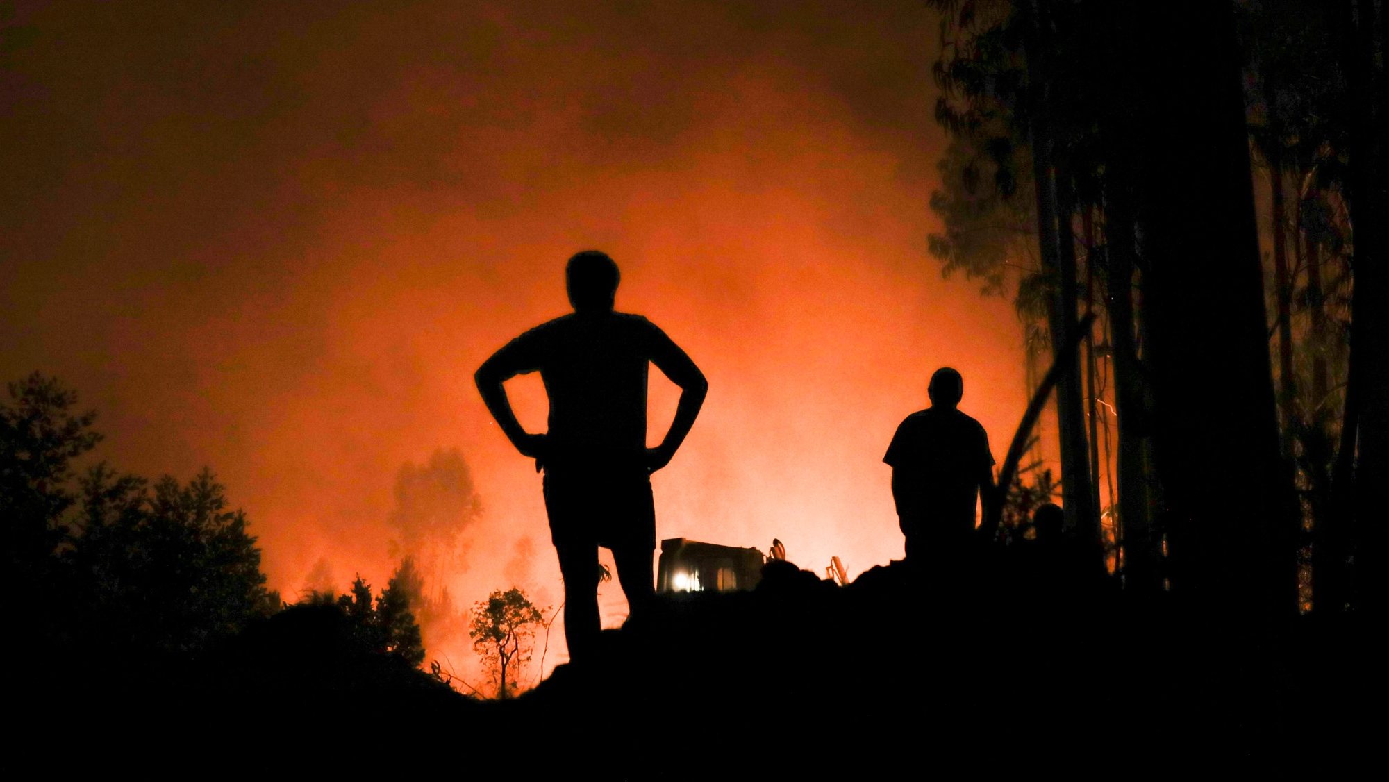 Inhabitants watch the forest fire in the village of Urqueira, Ourem, Portugal, 19 August 2022. At least 50 people were taken out of their homes today, as a precaution, due to the fire that has been raging since 2:40 pm in the municipality of Ourem, district of Santarem. PAULO CUNHA/LUSA