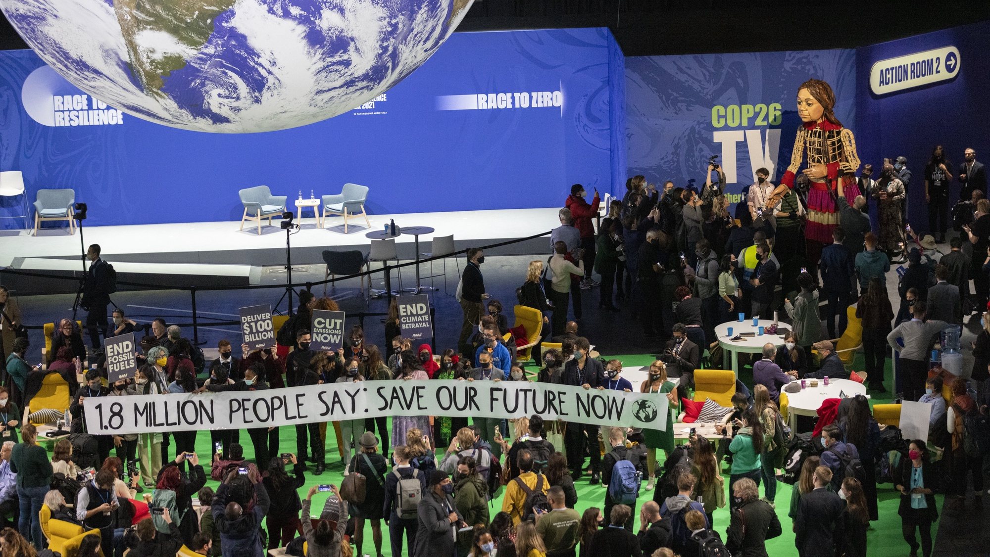 epa09572554 Delegates and participants gather around Little Amal (C), in the Hydro during the COP26 UN Climate Summit in Glasgow, Britain, 09 November 2021. Little Amal is the giant puppet of a 3.5 metre-tall living artwork of a young Syrian refugee child on &#039;The Walk&#039;, travelling 8,000km in 2021 in support of refugees across Turkey, Greece, Italy, France, Switzerland, Germany, Belgium and the UK to focus attention on the urgent needs of young refugees. The 2021 United Nations Climate Change Conference (COP26) runs from 31 October to 12 November 2021 in Glasgow.  EPA/ROBERT PERRY