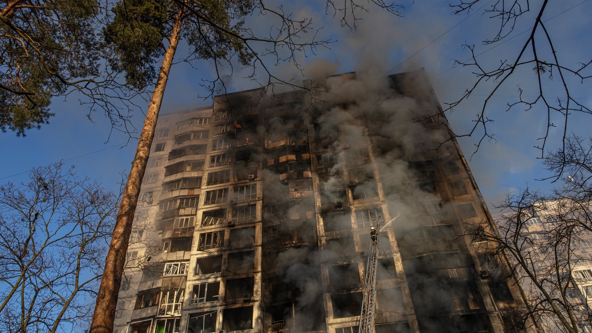 Bombeiros extinguem um incêndio um edifício bombardeado em Kiev