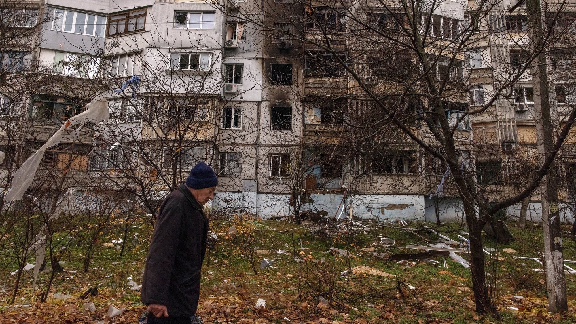 epa10327785 A man walks past at a damaged residential building after the recent Russian attack in Kherson, southern Ukraine, 25 November 2022. Russian troops for the past few days intensified the shelling of Kherson. On its retreat from Kherson, the Russian army destroyed critical infrastructure in the city, including electricity and water supplies. Now the lack of electricity and running water in the town during the winter season has forced many locals to flee Kherson.  EPA/ROMAN PILIPEY
