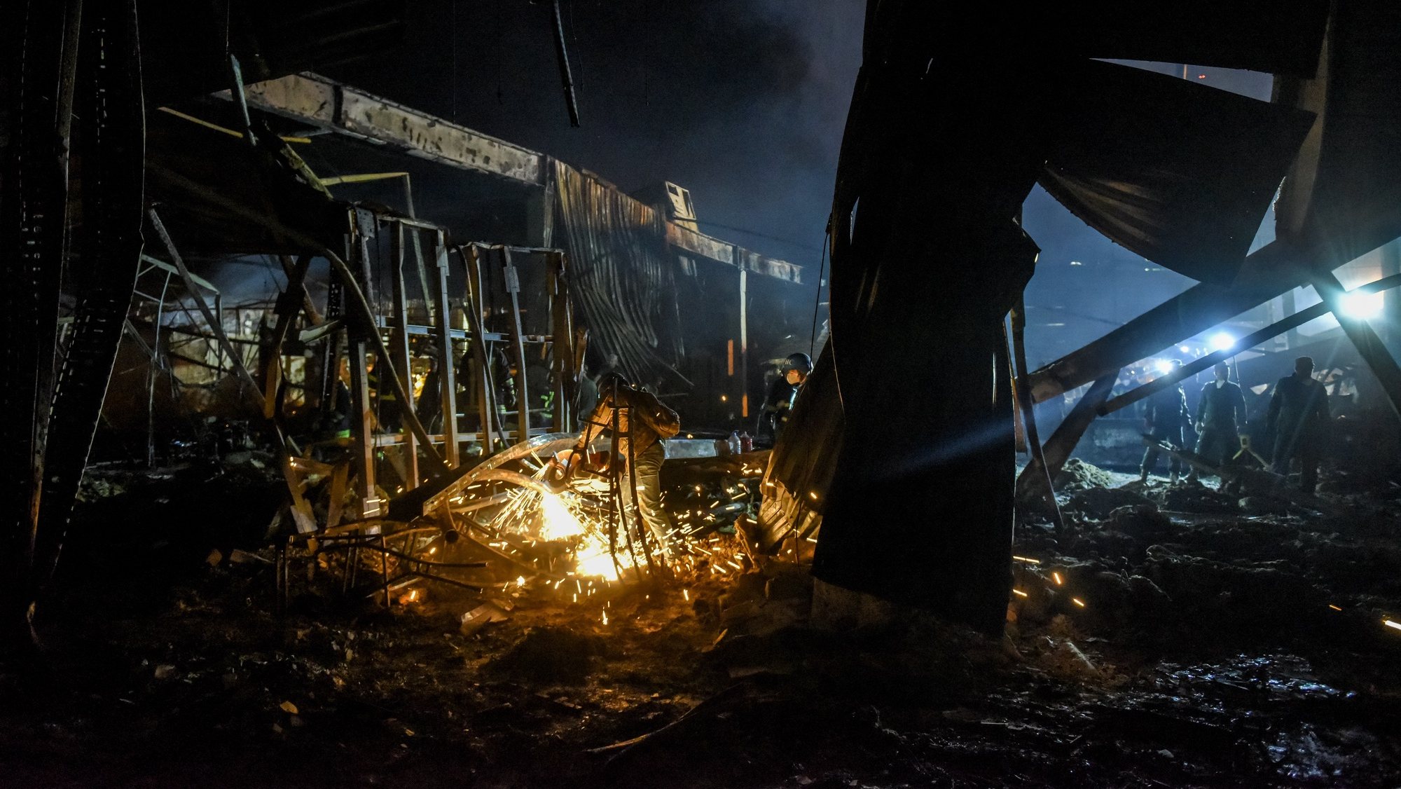 epa10037597 Firefighters clean the rubble of the destroyed Amstor shopping mall in Kremenchuk, Poltava Oblast, Ukraine, 27 June 2022. At least eleven bodies were found dead at the scene, the State Emergency Service (SES) of Ukraine said in a Telegram post, and at least 58  injured following Russian airstrikes on the crowded shopping mall. The one-story building of a shopping center was hit by Russian rockets in the afternoon.  EPA/OLEG PETRASYUK