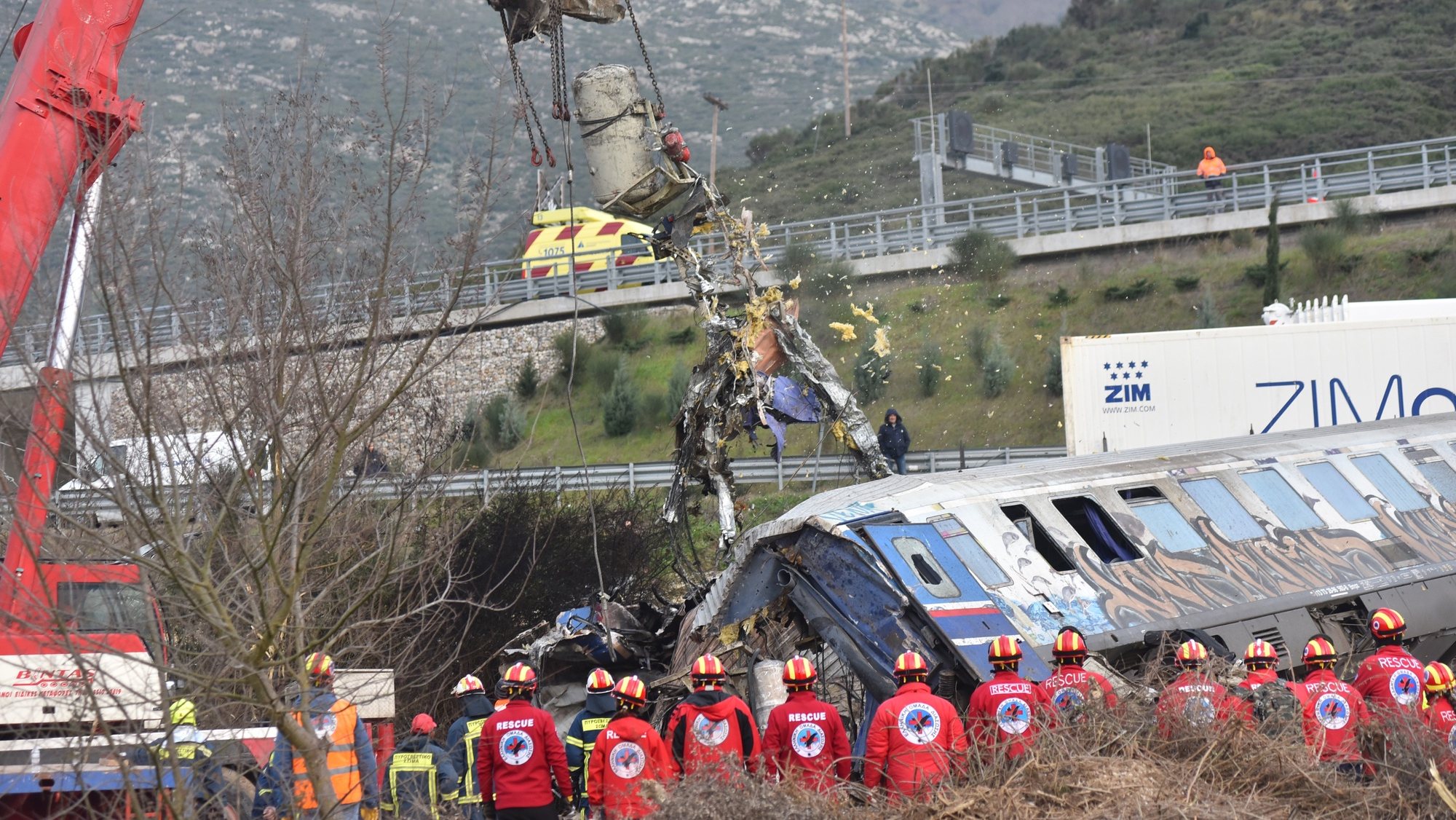 epa10497207 Crane vehicles try to remove pieces of damaged train wagons after a collision near Larissa city, Greece, 01 March 2023. Fire fighter and ambulance service crews remain at the scene, while special crews were using cutting tools and blow torches to cut and prise apart the remains of the carriages to look for people or bodies possibly trapped inside. According to the latest update by the fire brigade spokesperson Vasilis Vathrakogiannis, the death toll was 36 so far and 66 people had been taken to hospital, six of which were admitted to ICUs.  EPA/APOSTOLIS DOMALIS