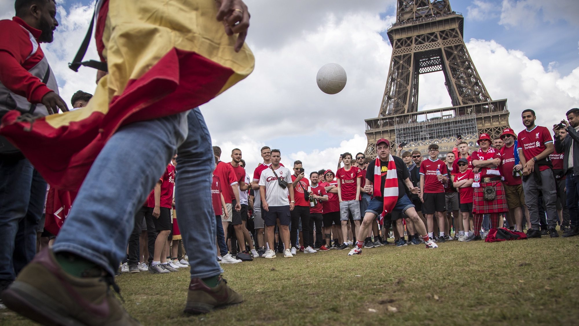 epaselect epa09981689 Liverpool and Real Madrid&#039;s fans play with a ball as they gather near the Eiffel Tower ahead of the UEFA Champions League final in Paris, France, 28 May 2022. Paris hosts the UEFA Champions League final between Real Madrid and Liverpool FC on 28 May 2022.  EPA/CHRISTOPHE PETIT TESSON