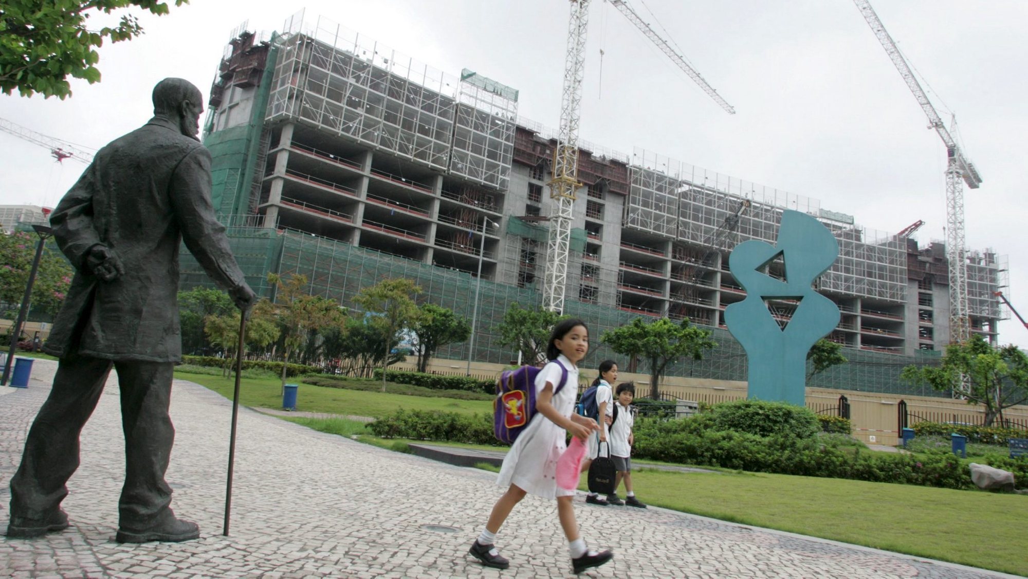 epa000420643 School children returning home walk past the construction site of the new Wynn Resorts casino in Macau, 25 April 2005. Looking on at right is a statue of the Portuguese poet, lawyer and magistrate Camillo Pessanha who died in 1926.Wynn Resorts (WYNN) announced Monday that it has been qualified to participate in the request for the proposal for an integrated resort, to be issued by the Singapore government in the second quarter of 2005. Wynn Resorts plans to open its multibillion-dollar Las Vegas casino resort, Wynn Las Vegas, on April 28 2005, and it&#039;s US$700 million Macau casino on the 6.5 hectare site to the public by the autumn of 2006.  EPA/STRINGER