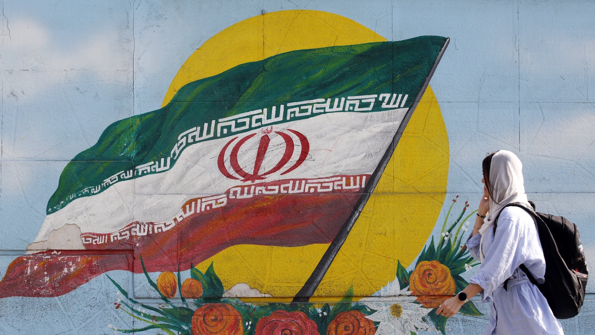 epa10295546 A woman walks past a graffiti showing the Iranian national flag in Tehran, Iran, 09 November 2022. Iran has been rocked by anti-government protests, with supporters worldwide, following the death in September 2022 of Masha Amini, a 22-year-old girl who died while in police custody after being detained for breaking Iran&#039;s strict dress code for women. Iranian leaders condemned the protests and accused the United States and Israel of planning the uprising.  EPA/ABEDIN TAHERKENAREH