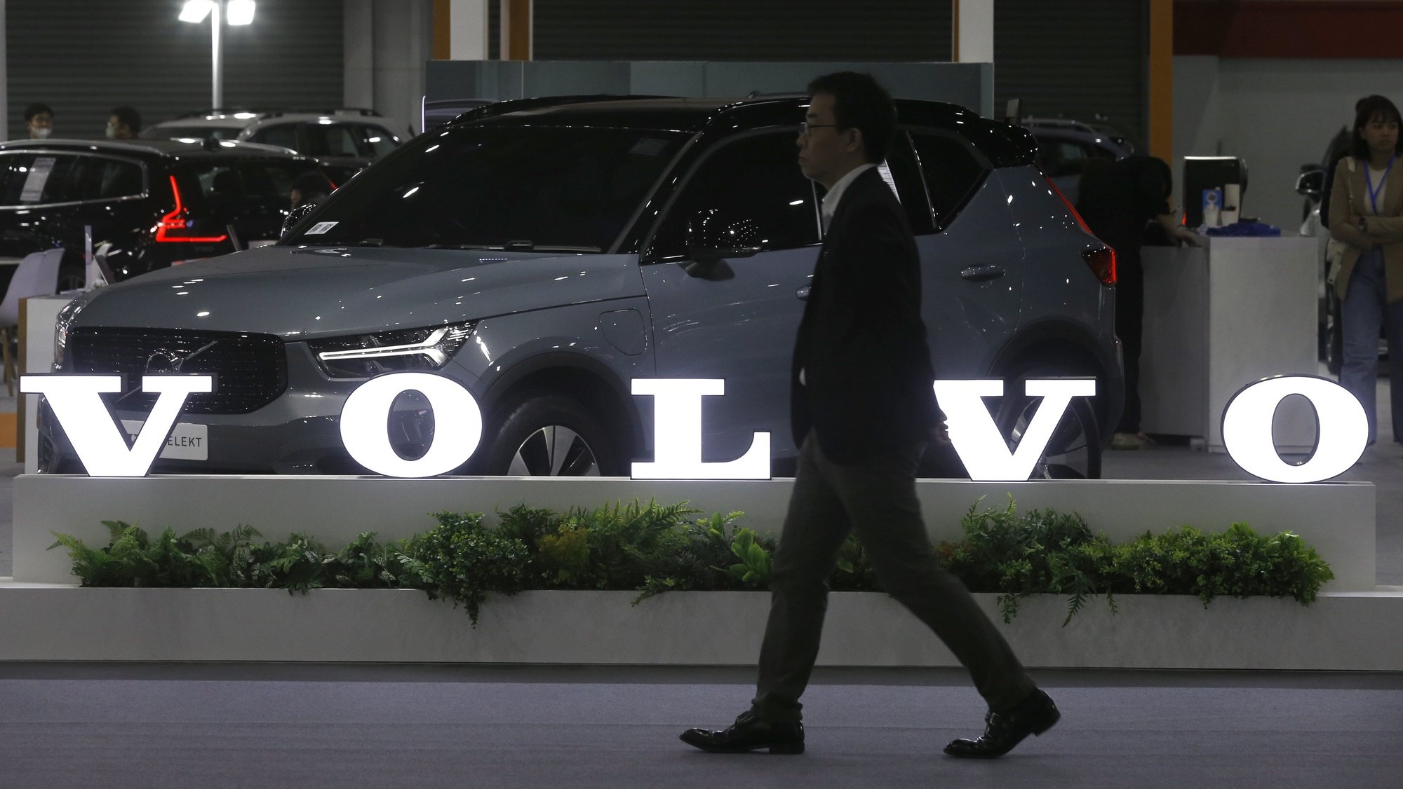 epa10727606 A visitor walks past the Volvo logo at the Fast Auto Show Thailand and EV Expo 2023 trade show at BITEC in Bangkok, Thailand, 05 July 2023. The event is held between 05 and 09 July and will include displaying EV innovations such as energy storage system by Nuovo Plus, PTT EV Charger electric charging station and a simulated EV Station Pluz charging station. According to the Federation of Thai Industries, more than 16,400 new EV cars were registered in the country in March 2023.  EPA/NARONG SANGNAK