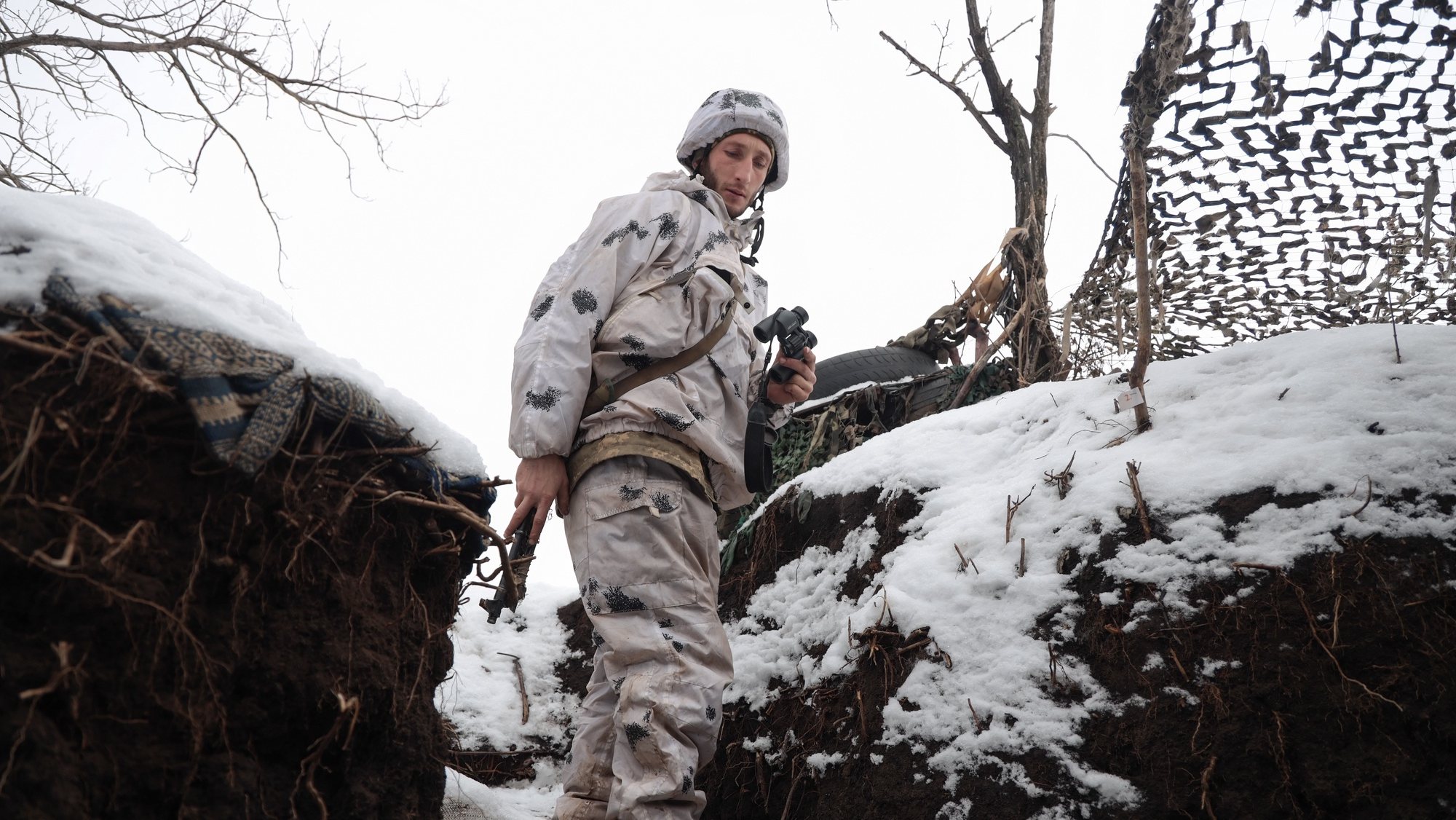 Um soldado ucraniano verifica a situação nas posições da linha da frente, não muito longe de onde os militares russos controlam a cidade de Horlivka, Ucrânia, 31 de janeiro de 2022