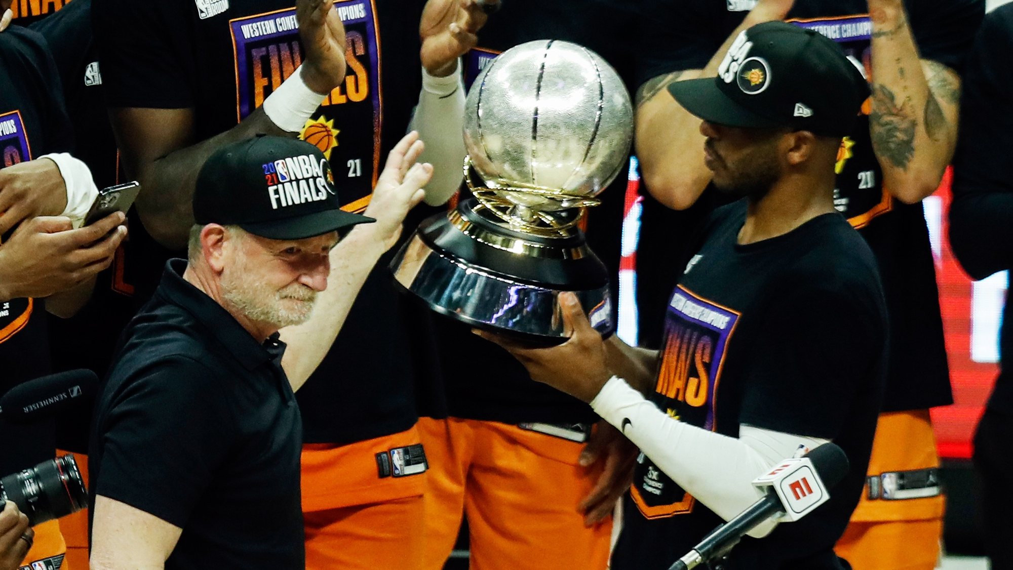 epa09314732 Phoenix Suns owner Robert Sarver (L) gives the Western Conference Trophy to Phoenix Suns guard Chris Paul (R) to lift  next to his teammates after winning game 6 of the NBA playoffs Western Conference final between the Phoenix Suns and the Los Angeles Clippers at the Staples Center in Los Angeles, California, USA, 30 June 2021.  EPA/ETIENNE LAURENT SHUTTERSTOCK OUT