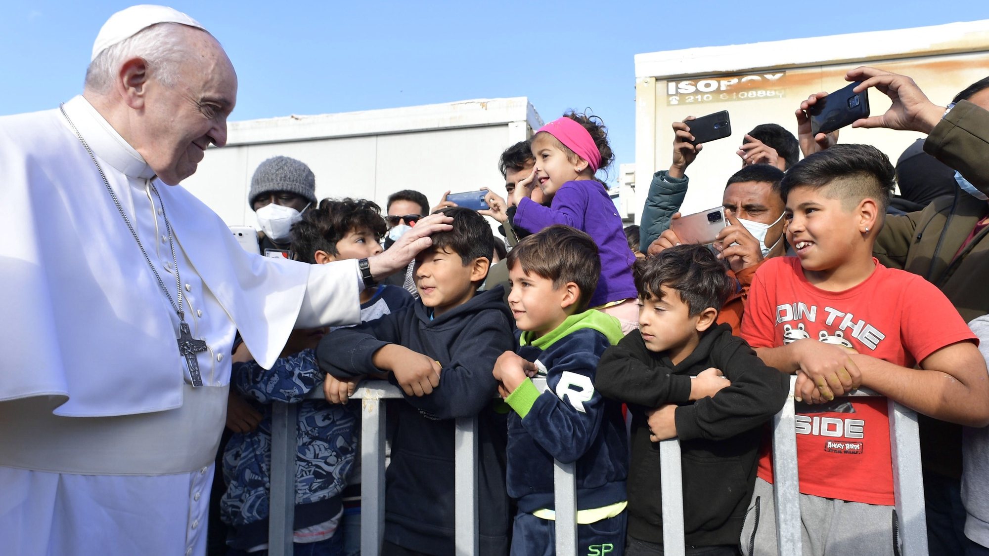 epa09623065 A handout picture provided by the Vatican Media shows Pope Francis blessing a boy at the Reception and Identification Centre (RIC) in Mytilene on the island of Lesbos, Greece 05 December 2021. Pope Francis returned to the island of Lesbos, the migration flashpoint he first visited in 2016, to plead for better treatment of refugees as attitudes towards migrants harden across Europe.  EPA/VATICAN MEDIA HANDOUT  HANDOUT EDITORIAL USE ONLY/NO SALES