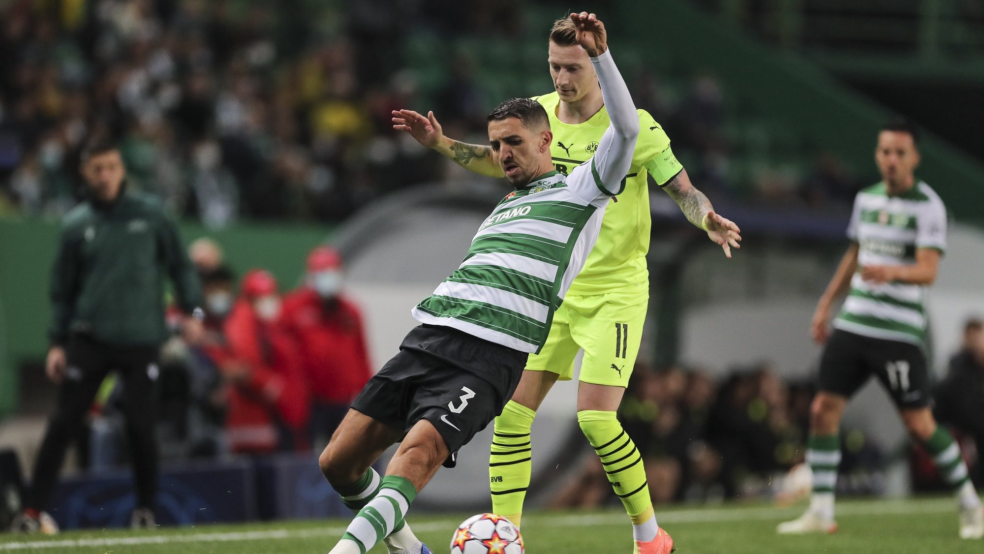 Sporting player Zouhair Feddal (L) fights for the ball with Borrusia Dortmund player Marco Reus (R) during the UEFA Champions League Group C soccer match at Alvalade Stadium in Lisbon, Portugal, 24 November 2021. MIGUEL A. LOPES/LUSA