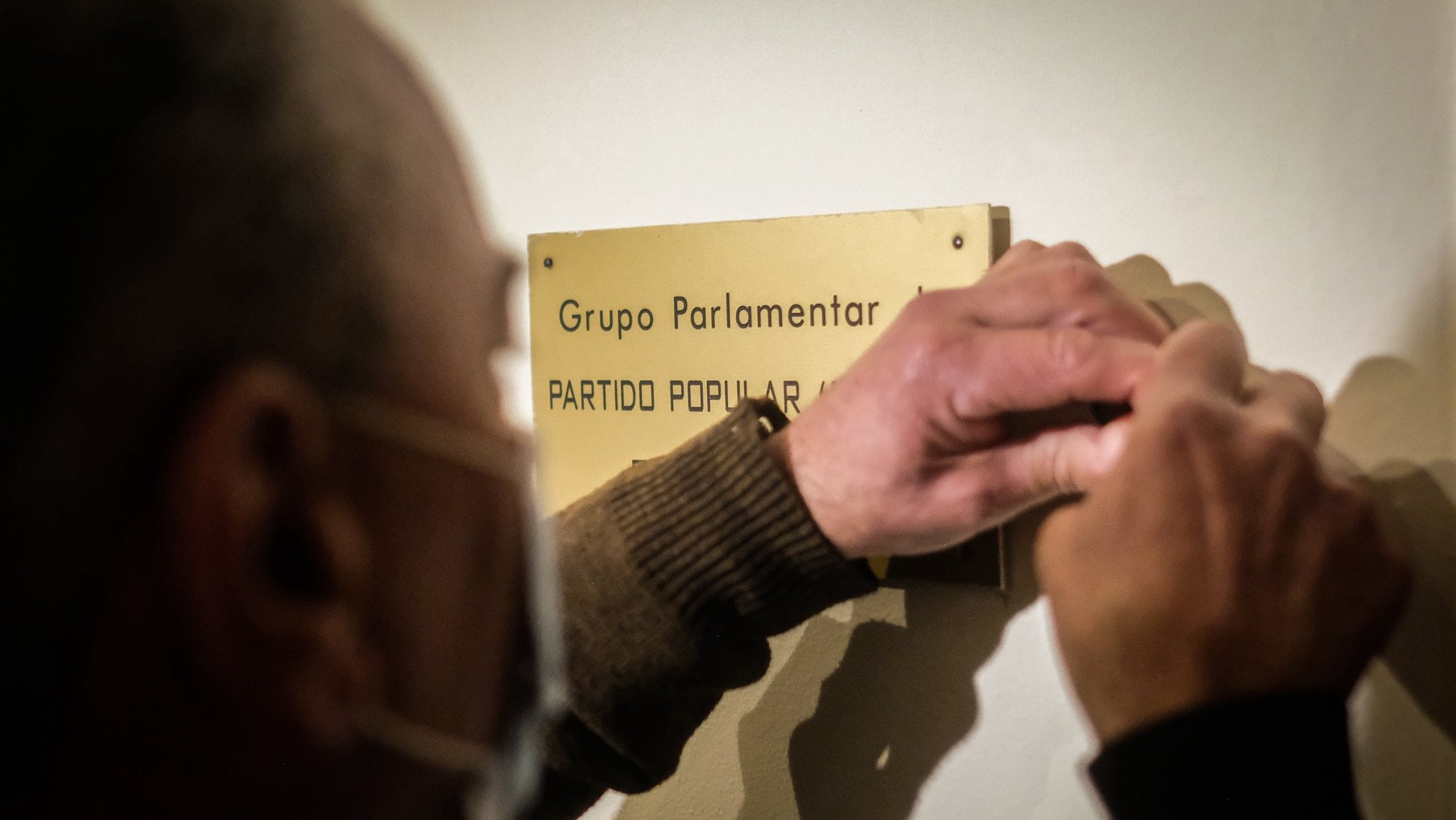 Um carpinteiro remove a placa do grupo parlamentar do CDS-PP na Assembleia da República, em Lisboa, 10 de fevereiro de 2022. O CDS-PP não elegeu nenhum deputado perdendo assim a representação parlamentar pela primeira vez na história do partido. MÁRIO CRUZ/LUSA