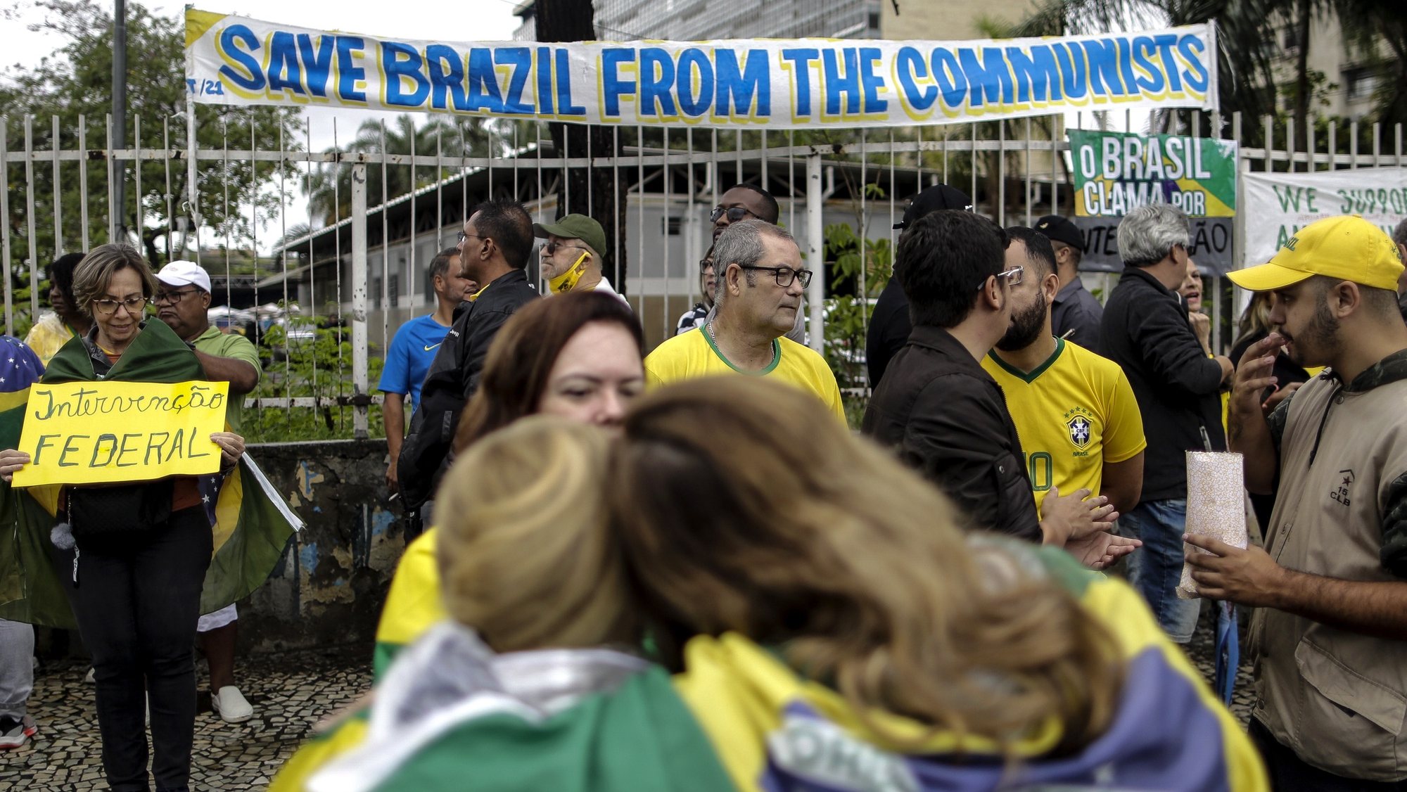 epa10281839 Supporters of outgoing Brazilian President Jair Bolsonaro gather near a banner reading &#039;Save Brazil from the communists&#039; during a protest against the election results, outside the Eastern Military Command in Rio de Janeiro, Brazil, 02 November 2022. Thousands of people have gathered in front of the gates of barracks in Sao Paulo, Brasilia and Rio de Janeiro to demand a &#039;military intervention&#039; against the electoral victory of progressive leader Luiz Inacio Lula da Silva. The rallies were organized through social networks by far-right groups that support Bolsonaro and do not recognize Lula&#039;s democratic election.  EPA/ANTONIO LACERDA