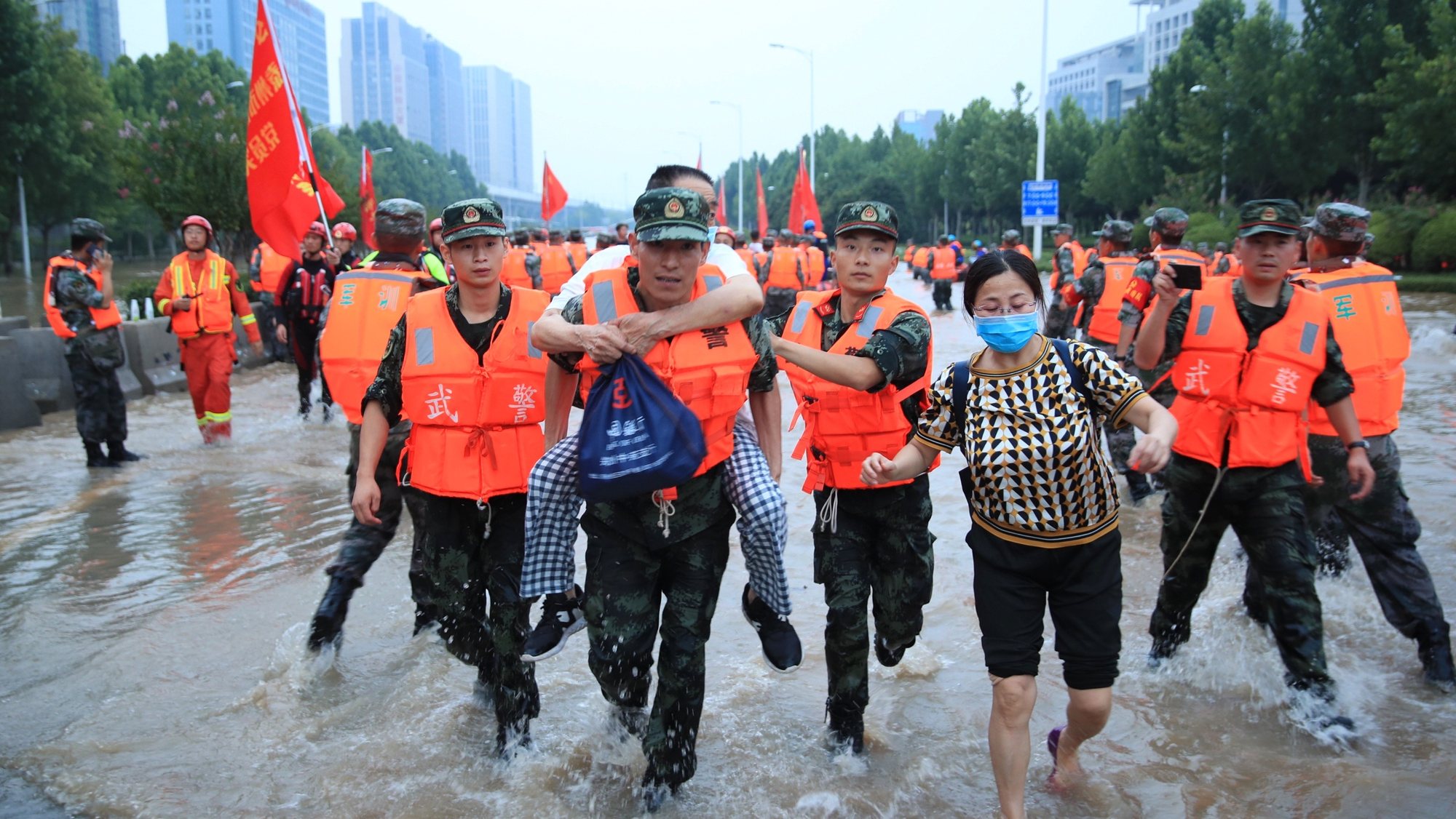 epa09358203 Rescuers evacuate people from a hospital where about 3,000 people were trapped by the flood in Zhengzhou, central China&#039;s Henan province, 22 July 2021. Thirty-three people were found dead in the flooding, and eight more are missing.  EPA/STRINGER CHINA OUT
