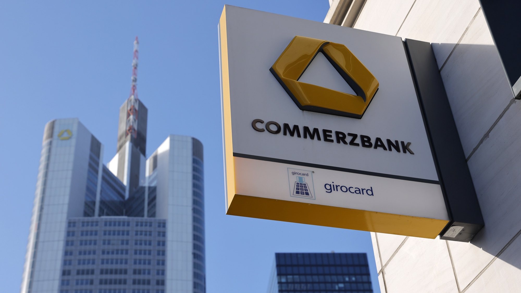 epa08998394 A view on the Commerzbank office tower seen behind a Commerzbank signage at its local branch in Frankfurt am Main, Germany, 09 February 2021. Commerzbank will release their preliminary business figures for the fourth quarter Q4 and the full year 2020 on 11 February 2021.  EPA/RONALD WITTEK