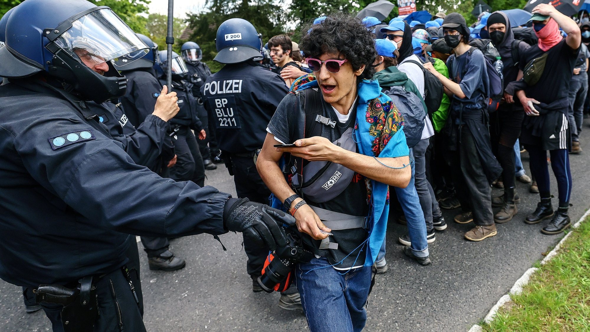 epa11331049 A protester reacts as police officers restrain environmental activists during a protest against Tesla&#039;s plans to extend its Gigafactory plant, in Gruenheide, near Berlin, Germany, 10 May 2024. Due to the ongoing protests, Tesla announced earlier this week it would suspend production at its factory in Gruenheide on 10 May.  EPA/FILIP SINGER
