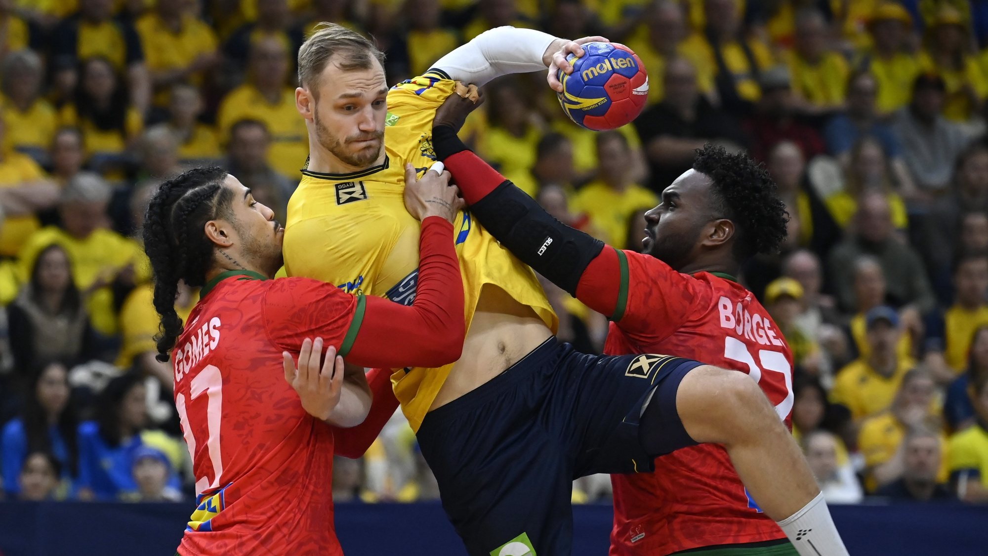 epa10423863 Sweden&#039;s Lukas Sandell (C) in action against Portugal&#039;s Andre Gomes (L) and Alexis Borges during the IHF Men&#039;s Handball World Championship Main Round group II third round match Sweden vs Portugal in Gothenburg, Sweden, 22 January 2023.  EPA/Tamas Kovacs HUNGARY OUT