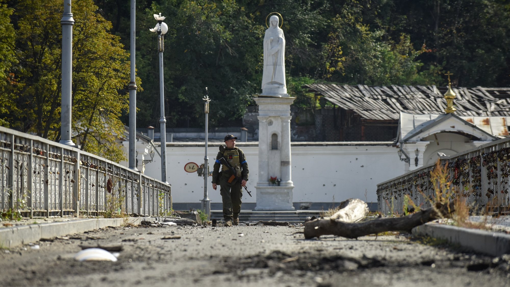 epa10218534 Pavlo, serviceman of Yuriy Kulchytsky battalion of National Guard of Ukraine, walks on damaged bridge near Holy Mountains Lavra of the Holy Dormition in Sviatohirsk town in Donetsk region, Ukraine, 01 October 2022. The Ukrainian army pushed Russian troops from occupied territory in the northeast of the country in a counterattack. Kharkiv and surrounding areas have been the target of heavy shelling since February 2022, when Russian troops entered Ukraine starting a conflict that has provoked destruction and a humanitarian crisis.  EPA/OLEG PETRASYUK