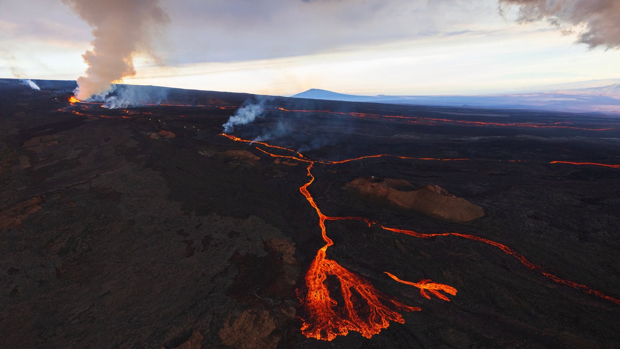 epa10340658 The world&#039;s largest active volcano, Mauna Loa, continues to erupt from its northeast rift, sending multiple rivers of lava downslope to the north, with one lobe flowing east in the direction of Hilo, on the Island of Hawaii, Hawaii, USA, 30 November 2022.  EPA/BRUCE OMORI/PARADISE HELICOPTERS