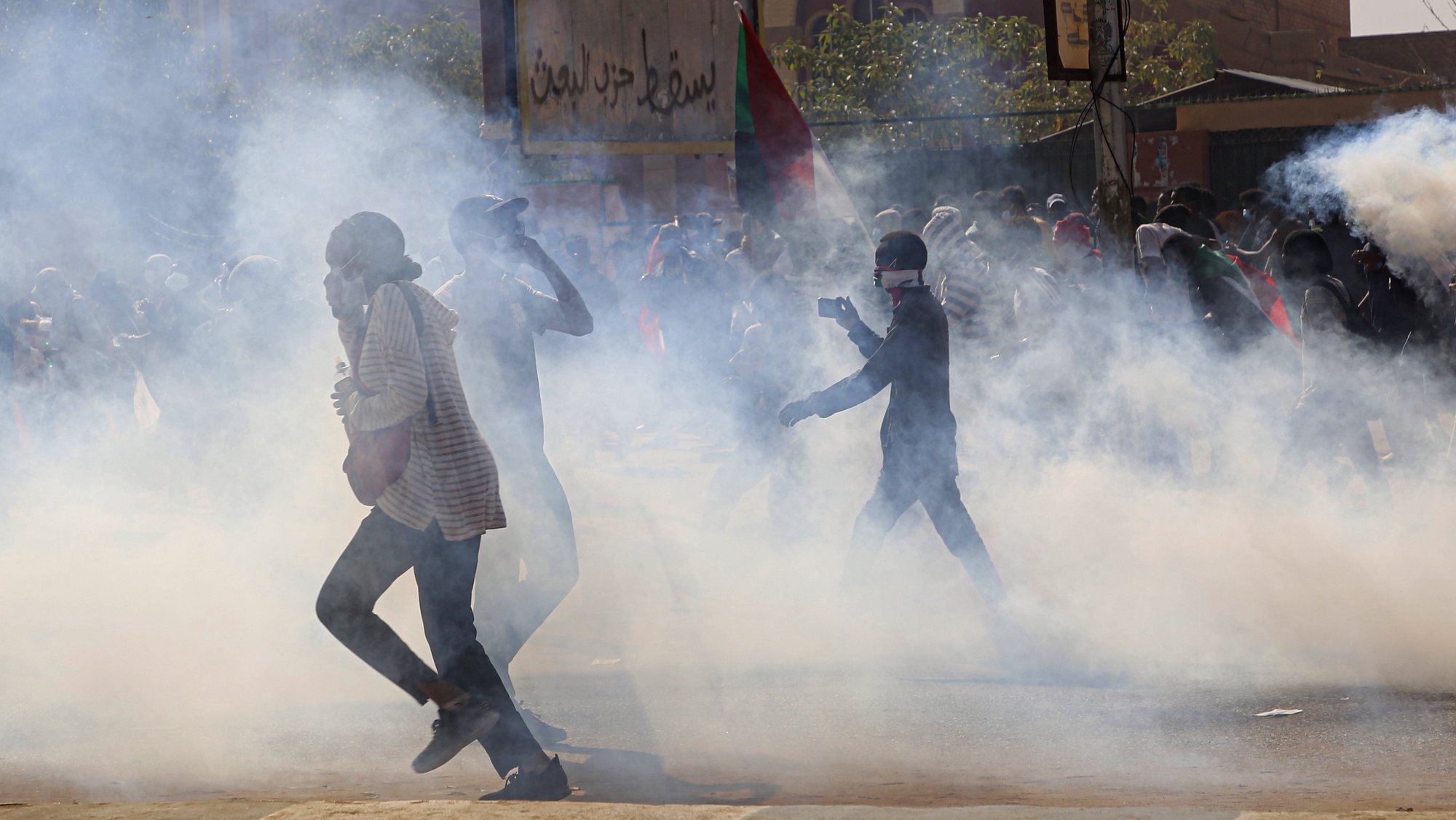epaselect epa09650631 Sudanese security forces fire tear gas as protestors clash with them during protest in front of the main door of the Republican Palace in the capital Khartoum, Sudan, 19 December 2021. Tens of thousands of protesters marched during a demonstration marking the third anniversary of the start of mass demonstrations that led to the ousting of the dictator al-Bashir.  EPA/STRINGER