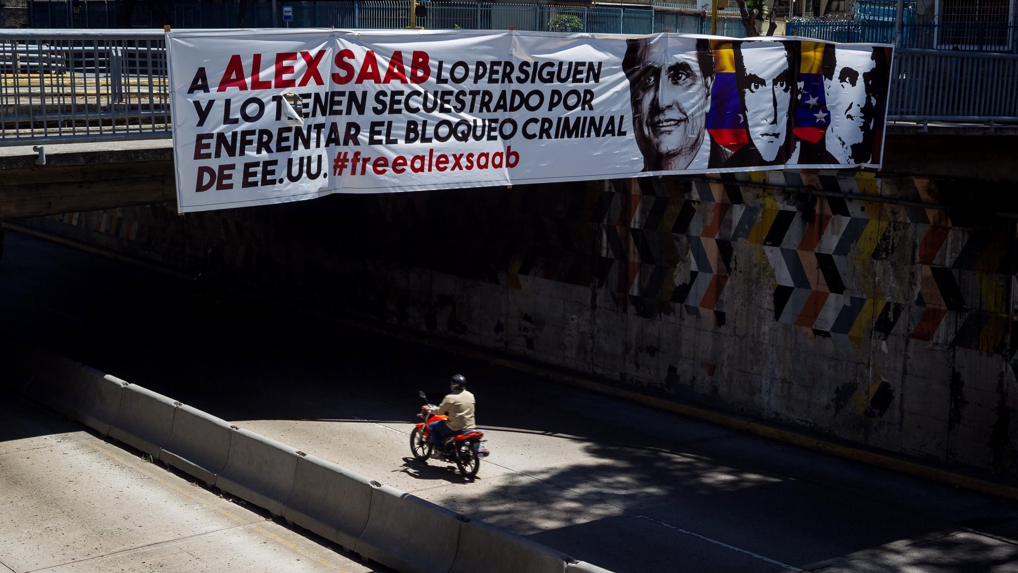 epa09024180 A banner in support of Alex Saab hangs from a bridge in Caracas, Venezuela, 19 February 2021. Venezuelan diplomat Alex Saab was arrested in Cape Verde in June 2020 at the request of the USA for alleged financial crimes, he was later placed under house arrest in January 2021.  EPA/Miguel GutiÃ©rrez