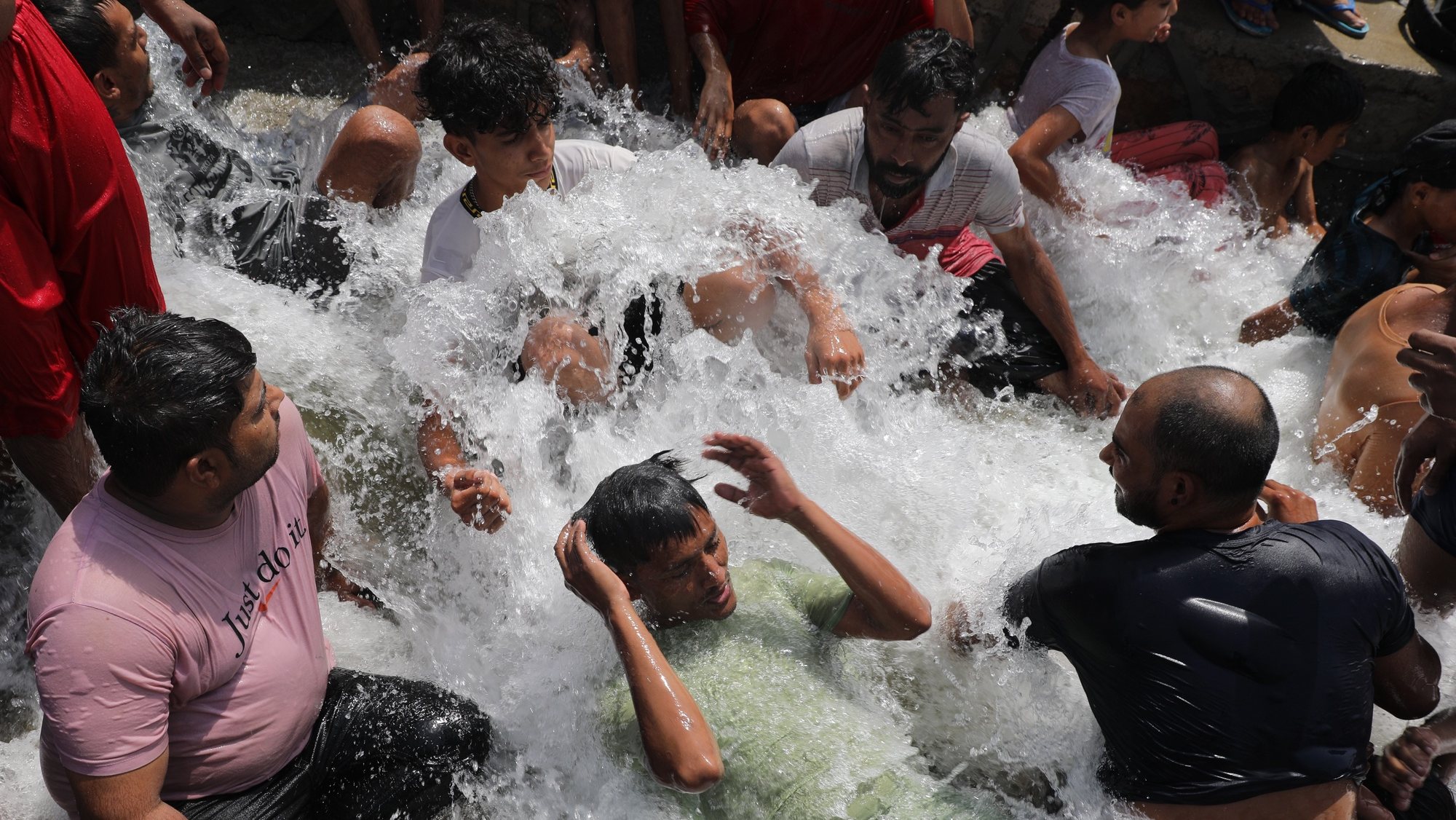epa11381760 Indian people take bath in water which was flowing into a lake on hot day in New Delhi, India, 31 May 2024. The India Meteorological Department (IMD) has issued a heat red alert for Delhi, Rajasthan, Haryana, Punjab, and Madhya Pradesh. The IMD Director General M Mohapatra said they are checking the temperature sensor in Delhi&#039;s Mungeshpur automatic weather station to see if it is working properly, as there were temperatures of over 50 degrees Celsius recorded on 29 May, and the weather department has reported that the maximum temperature is anticipated to reach around 44 degrees Celsius, in the Indian capital.  EPA/RAJAT GUPTA