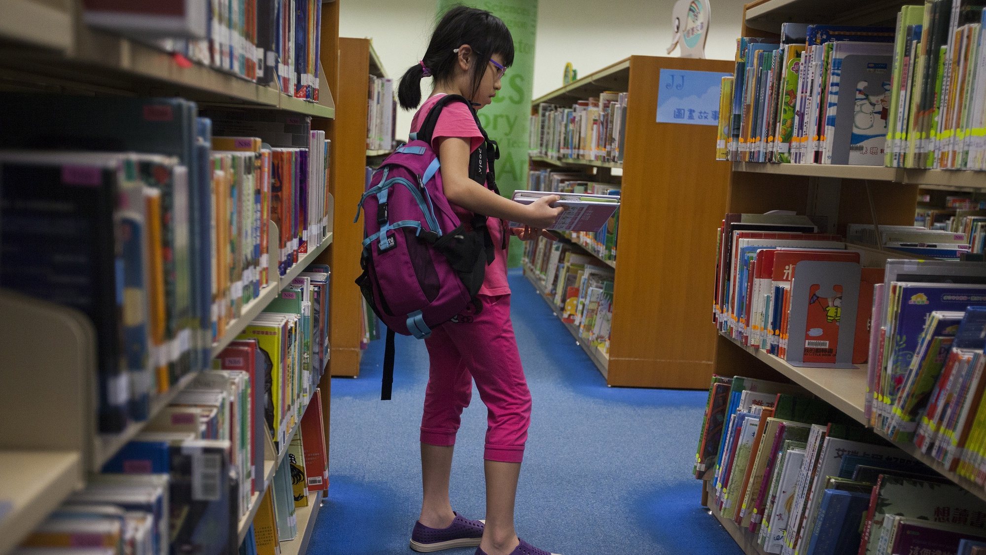 epa06826586 A child browses books at a public library in Tseung Kwan O, Sai Kung District, New Territories, Hong Kong, 21 June 2018. The Hong Kong government has come under fire from gay rights activists in the city for removing from the shelves of all of its public libraries ten LGBTQ (Lesbian, Gay, Bisexual, Trans, Queer/Questioning) themed books for children, allegedly under pressure from Christian fundamentalist anti-gay rights groups. Due to a sudden surge in demand for the ten controversial books, none are available for borrowing from the &#039;closed stack&#039; sections of Hong Kong libraries until 2019 at the earliest. &#039;Closed stacks&#039; are storage sections in public libraries where library staff place books out of sight whilst off the shelves, but can these books can be retrieved by members of the public on demand.  EPA/ALEX HOFFORD