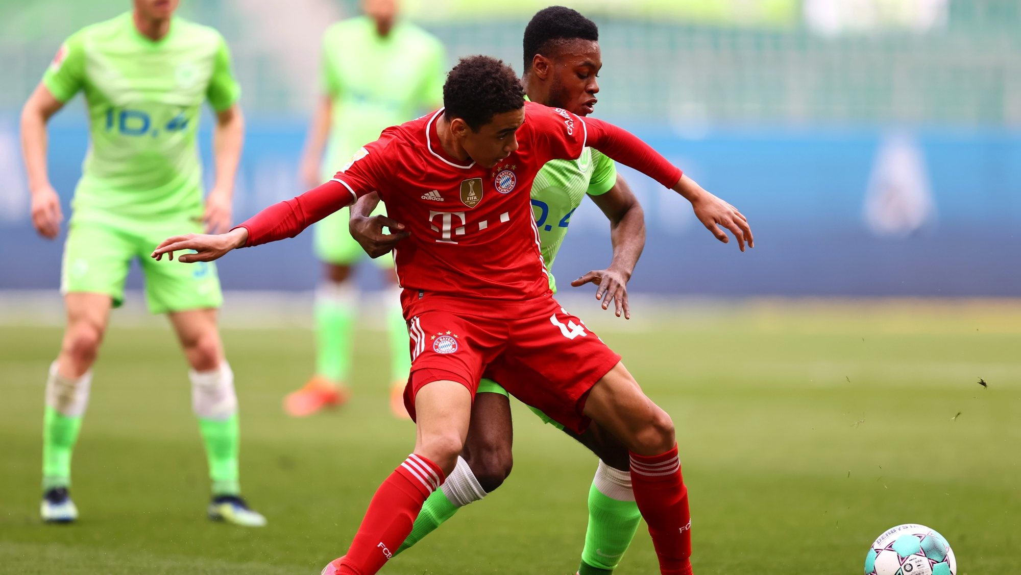 epa09141521 Jamal Musiala (L) of FC Bayern Muenchen is challenged by Ridle Baku of VfL Wolfsburg during the Bundesliga match between VfL Wolfsburg and FC Bayern Munich at Volkswagen Arena in Wolfsburg, Germany, 17 April 2021.  EPA/MARTIN ROSE / POOL DFL regulations prohibit any use of photographs as image sequences and/or quasi-video.