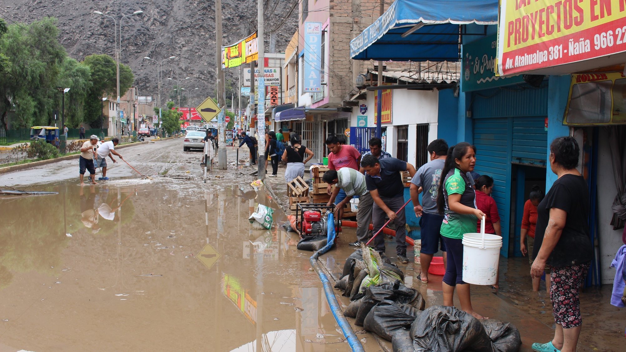 epa10524845 Residents try to get water out from their houses and stores flooded by Cyclone Yaku, in the district of Chaclacayo in Lima, Peru, 15 March 2023. The intense rains that fell in the early hours have caused mudslides and flooding in the districts of Cieneguilla, Chosica, Chaclacayo, Ate, San Juan de Lurigancho, Carabayllo and Punta Hermosa, but so far without reported deaths.  EPA/Paula Bayarte