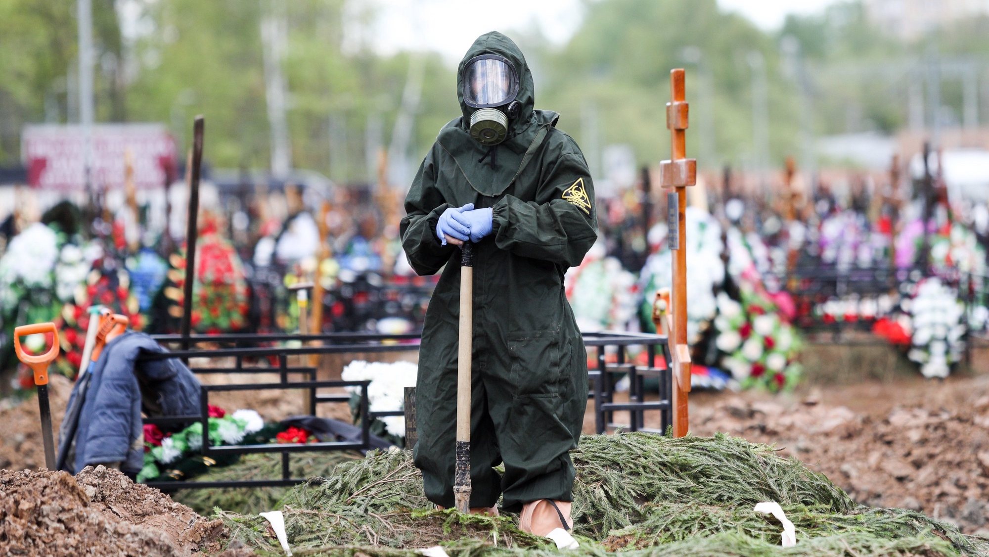 epa08424203 A handout picture made available by Moscow News Agency shows a cemetery worker wearing a protective suit during a burial ceremony of COVID-19 victim at the Butovskoye Cemetery in Moscow, Russia, 15 May 2020. According to official data, as of 15 May 2020, the total number of deaths in Russia from COVID-19 disease which is caused by SARS-CoV-2 coronavirus, exceeded 2,400 people, with over 1,350 in Moscow.  EPA/Zykov Kirill / Moscow News Agency Handout MANDATORY CREDIT / HANDOUT EDITORIAL USE ONLY/NO SALES