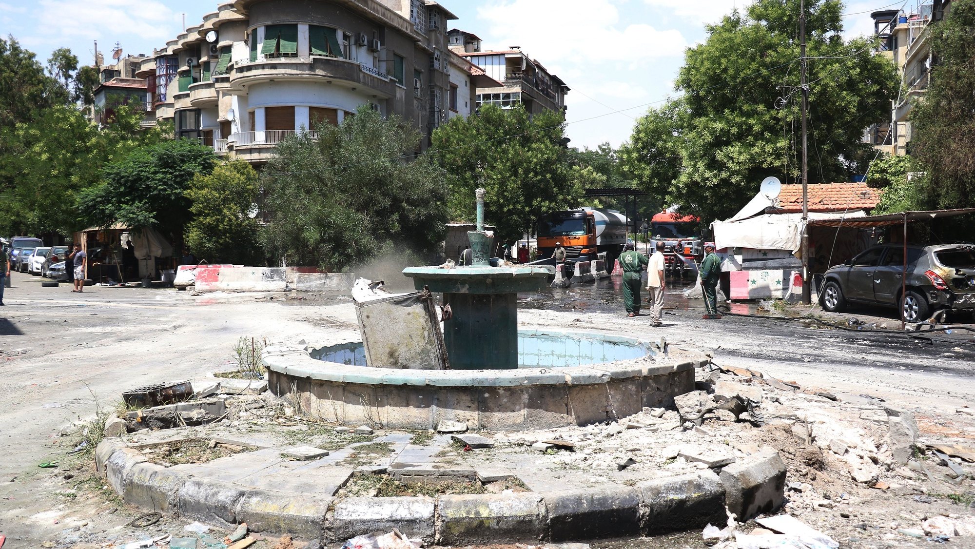 epa06061458 A general view of a damaged fountain near the site of a car bomb explosion in downtown Damascus, Syria, 02 July 2017. According to the state TV, three car bomb blasts rocked the capital  Damascus on 02 July that killed at least eight people and wounded a dozen others. It said that three car bombs went off at the Airport Road and al-Amara neighborhood in Damascus city. It indicated that the authorities chased the three cars and managed to intercept two of them near the entrance of Damascus city at the airport roundabout and destroyed them, but the third car managed to arrive in the capital and the suicide bomber on board detonated it, killing a number of people and injuring others.  EPA/YOUSSEF BADAWI