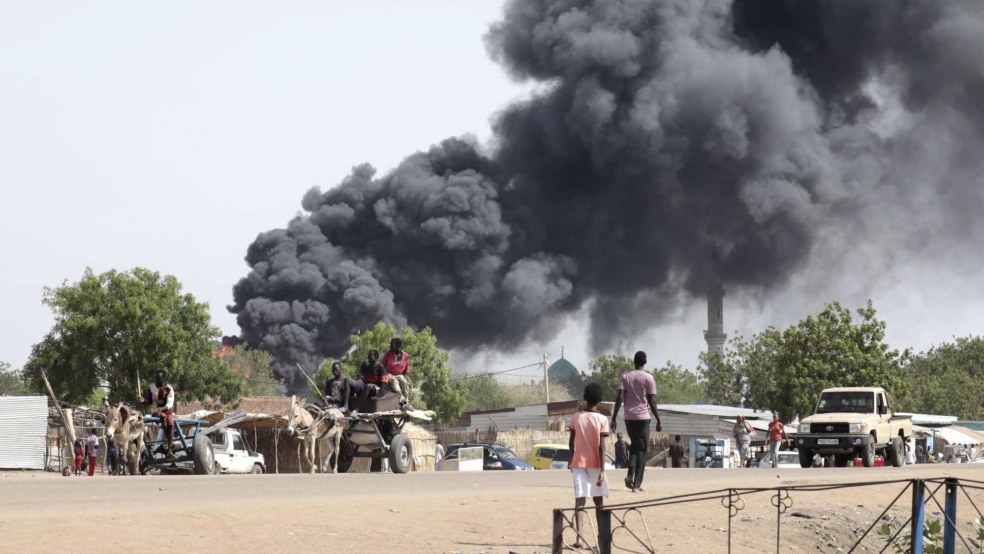 epaselect epa10625669 People drive as smoke rises from a fire at a market in the Upper Nile State town of Renk, South Sudan, 13 May 2023. According to UNHCR, at least 40,000 people have arrived into South Sudan since armed clashes between Sudan&#039;s military and rival paramilitary groups began in Khartoum and other parts of the country on 15 April 2023. Most of the refugees are part of the some 800,000 South Sudanese who had previously fled the war in South Sudan and who are now returning to a country with tensions still remaining in many areas, and more than two million internally displaced people. Upon arriving at the Joda border crossing, the refugees head to a transit area set up by UNHCR in the small town of Renk, where various UN agencies assist them with registration, food, health check and logistics.  EPA/AMEL PAIN