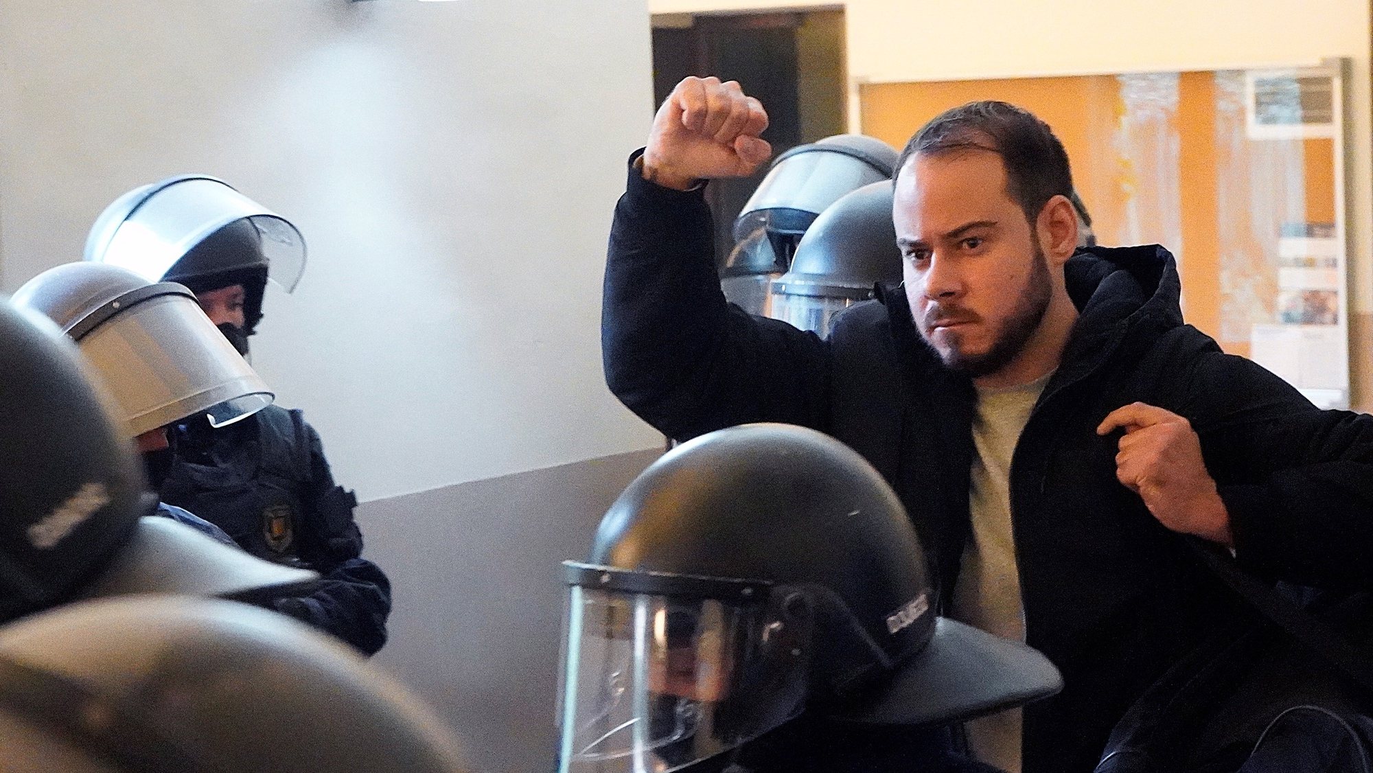 epa09015946 Spanish rapper Pablo Hasel raises his fist as he is arrested by Mossos d&#039;Esquadra police inside Lleida University after the deadline of his voluntary entry to prison has passed, in Lleida, Catalonia, Spain, 16 February 2021. Hasel was sentenced to a nine months in jail late January after the Supreme Court found him guilty of glorifying terrorism and insulting the crown and state institutions, triggering rallies of Rights Associations demanding free speech and for the government political parties (Unidas Podemos and Socialist Partty) to reform the criminal code for crimes involving freedom of expression.  EPA/Paul de la Calle