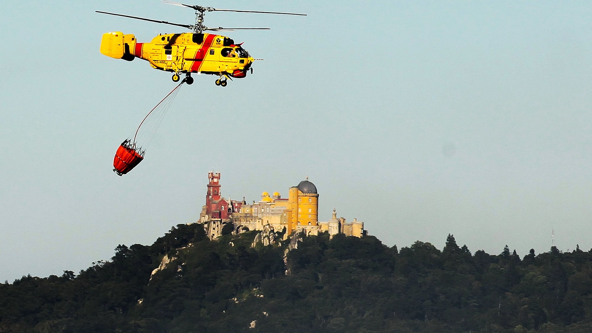 Um helicóptero combate o incêndio que deflagrou hoje numa área de mato ao início da tarde na Quinta da Capela, Sintra, 11 julho 2012. O fogo mobilizou 197 operacionais (194 bombeiros e três elementos de outras forças de socorro), 60 veículos e cinco meios aéreos. ANTONIO COTRIM/LUSA