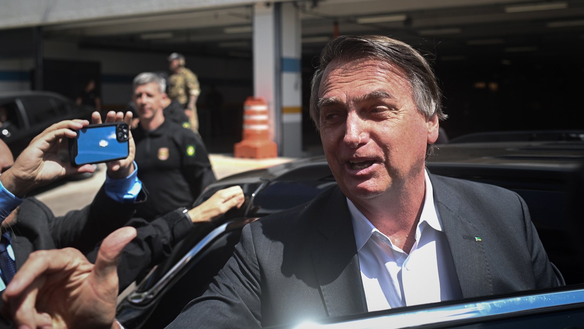epa10592679 Former president of Brazil Jair Bolsonaro leaves the headquarters of the Federal Police after giving testimony, for the anti-democratic attacks that took place in January, in Brasilia, Brazil, 26 April 2023. Bolsonaro testified for about two hours before the police and denied any responsibility in the coup on January 8, which allegedly tried to overthrow the government of Luiz Inacio Lula da Silva.  EPA/Andre Borges