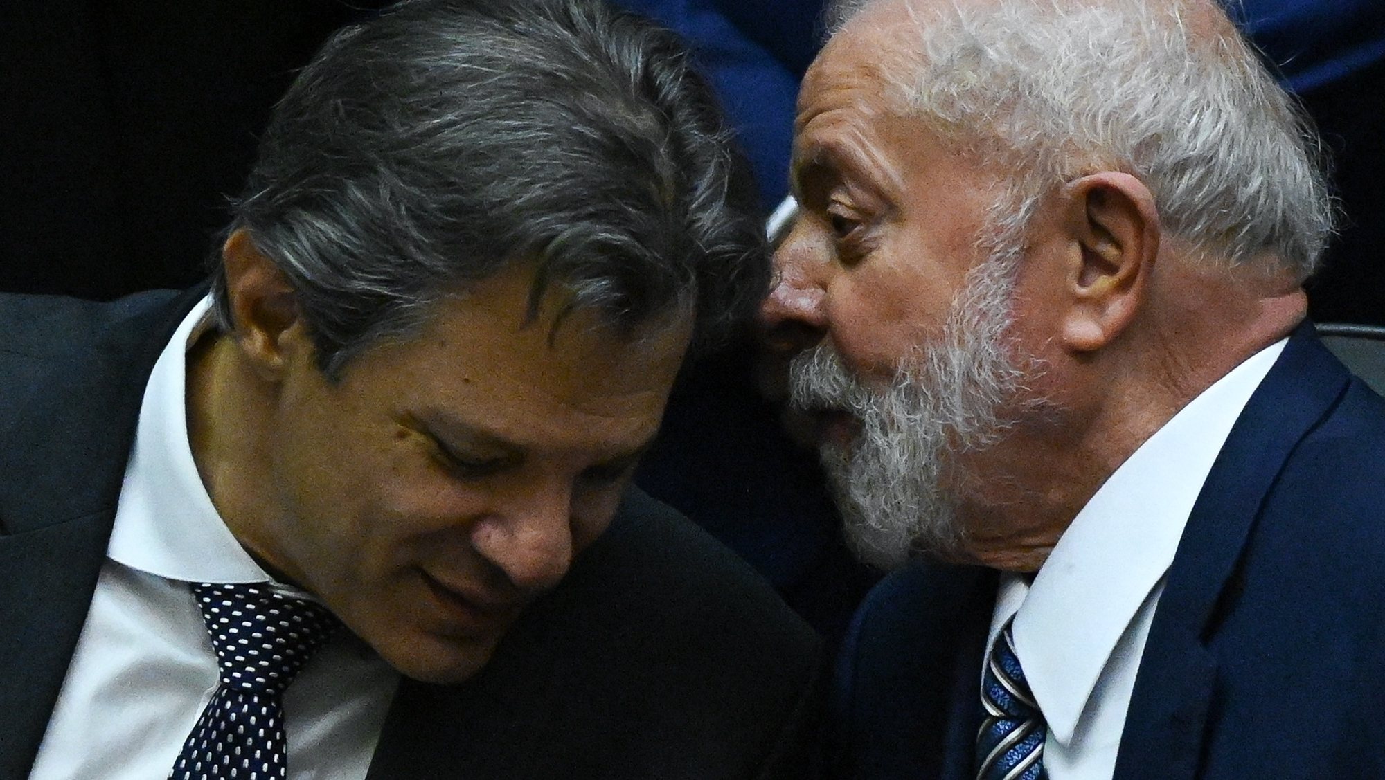 epa11039439 Brazilian President Luiz Inacio Lula da Silva (R) speaks with Brazilian Ministry of Treasury Fernando Haddad during a session where a new taxe law was approved during a session at the Brasilian National Congress in Brasilia, Brazil, 20 December 2023.  EPA/Andre Borges