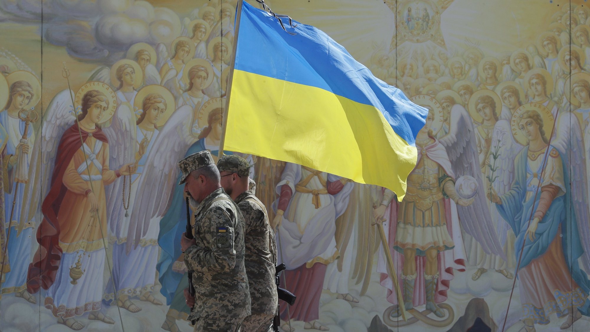epa10169878 Ukrainian soldiers carry the national flag in front of frescos at St. Mikhailovsky Cathedral in Kyiv (Kiev), Ukraine, 08 September 2022, amid the Russian invasion. Russian troops entered Ukraine on 24 February 2022 starting a conflict that has provoked destruction and a humanitarian crisis.  EPA/SERGEY DOLZHENKO