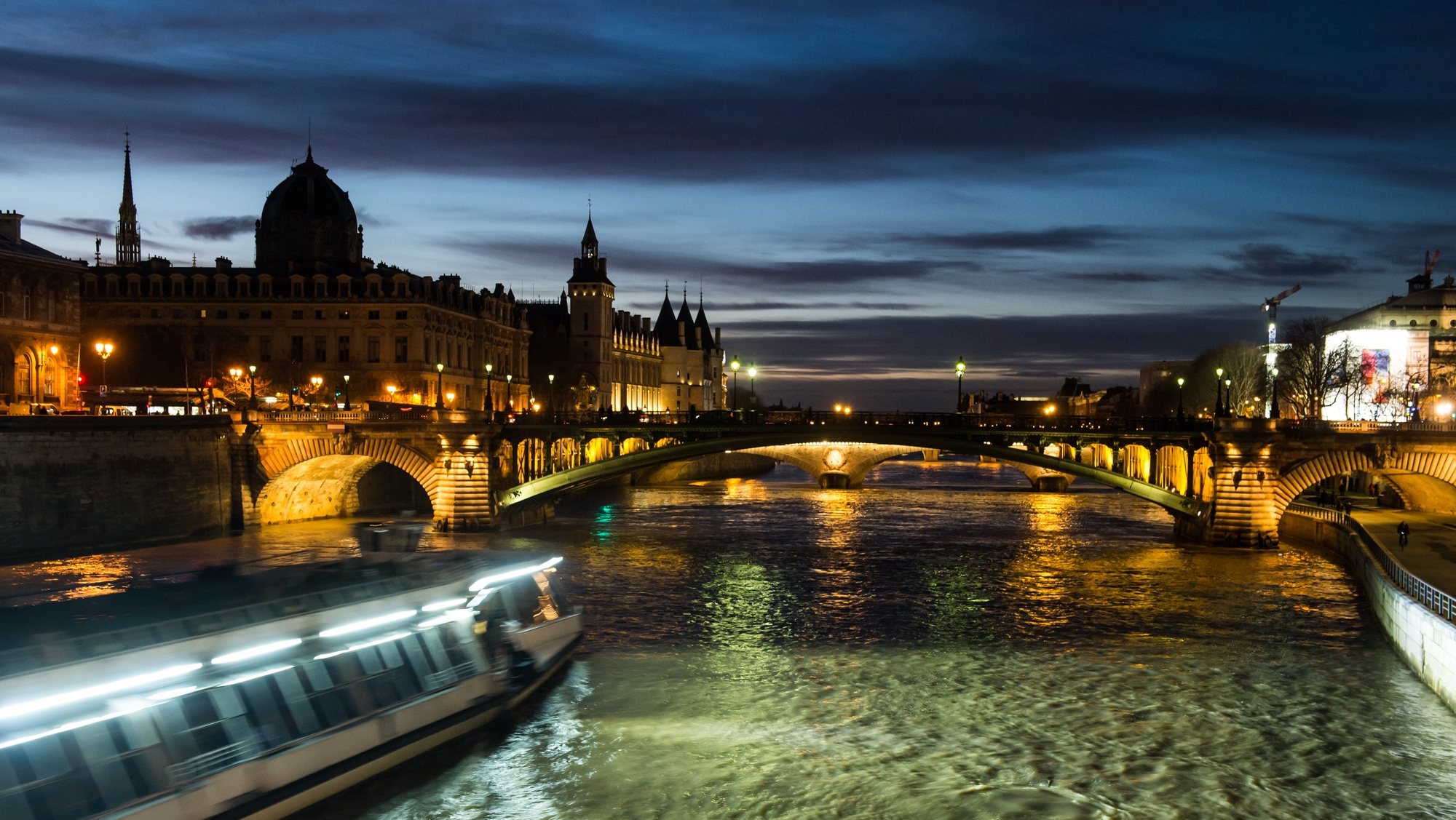 epaselect epa06394201 A night view of a tourist boat on the Seine river in front of the Ile de la Cite island (L) in the historic center of Paris, France, 16 December 2017.  EPA/CHRISTOPHE PETIT TESSON
