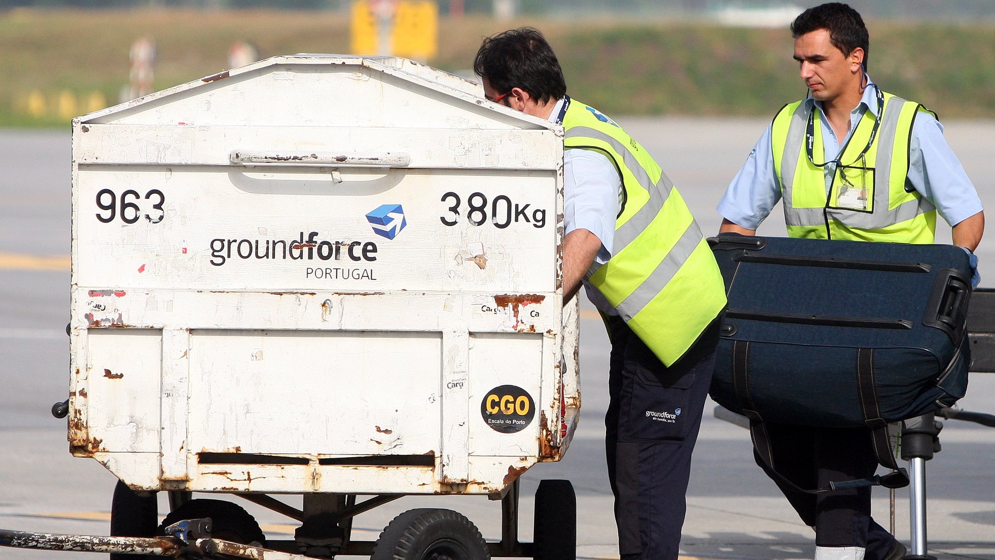 Funcionários da Groundforce carregam um carrinho com malas, no aeroporto Francisco Sá Carneiro, Porto, 27 de junho de 2012. JOSE COELHO/LUSA