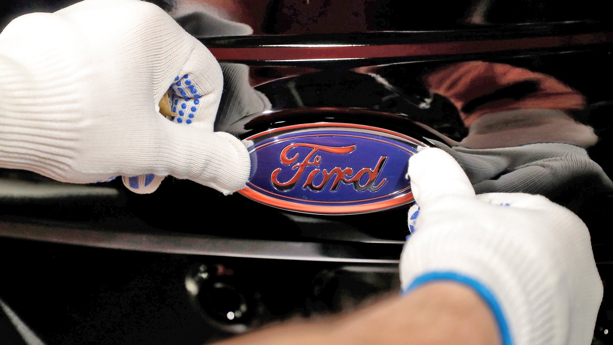 epa09018145 (FILE) - A worker attaches the Ford logo to a Fiesta car at the US car manufacturer plant Ford in Cologne, Germany, 18 January 2019   (reissued 17 February 2021). Ford on 17 February 2021 said all Ford passenger vehicles sold in Europe will either be hybrid or fully electric by mid-2026. Ford further said all of its passenger vehicles will be fully electric by 2030.  EPA/FRIEDEMANN VOGEL *** Local Caption *** 54928264
