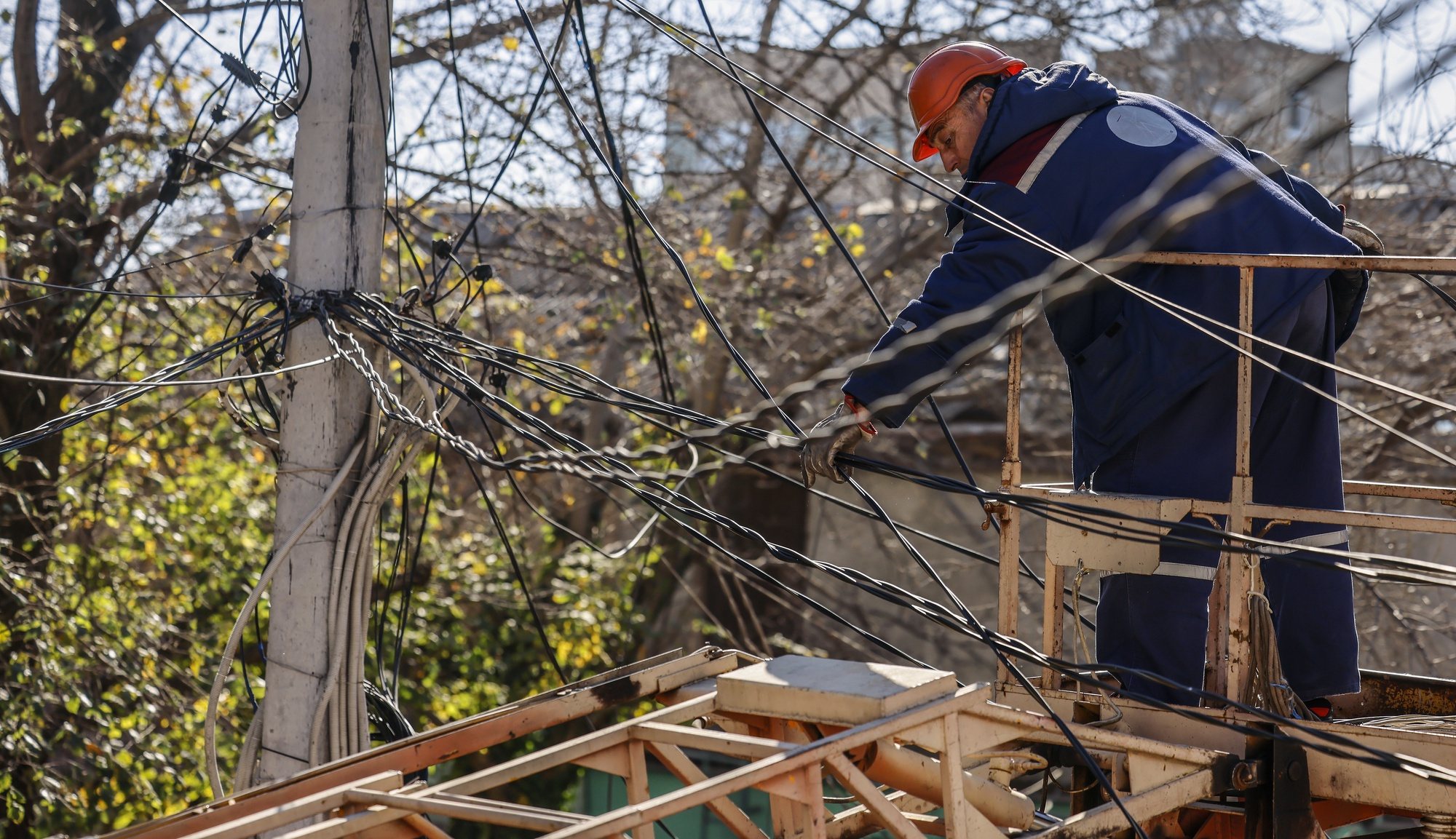 epa10278710 A worker repairs powerlines in Mykolaiv, Ukraine, 01 November 2022. Four missiles hit the city area the night before. Russian troops on 24 February entered Ukrainian territory, starting a conflict that has provoked destruction and a humanitarian crisis.  EPA/HANNIBAL HANSCHKE