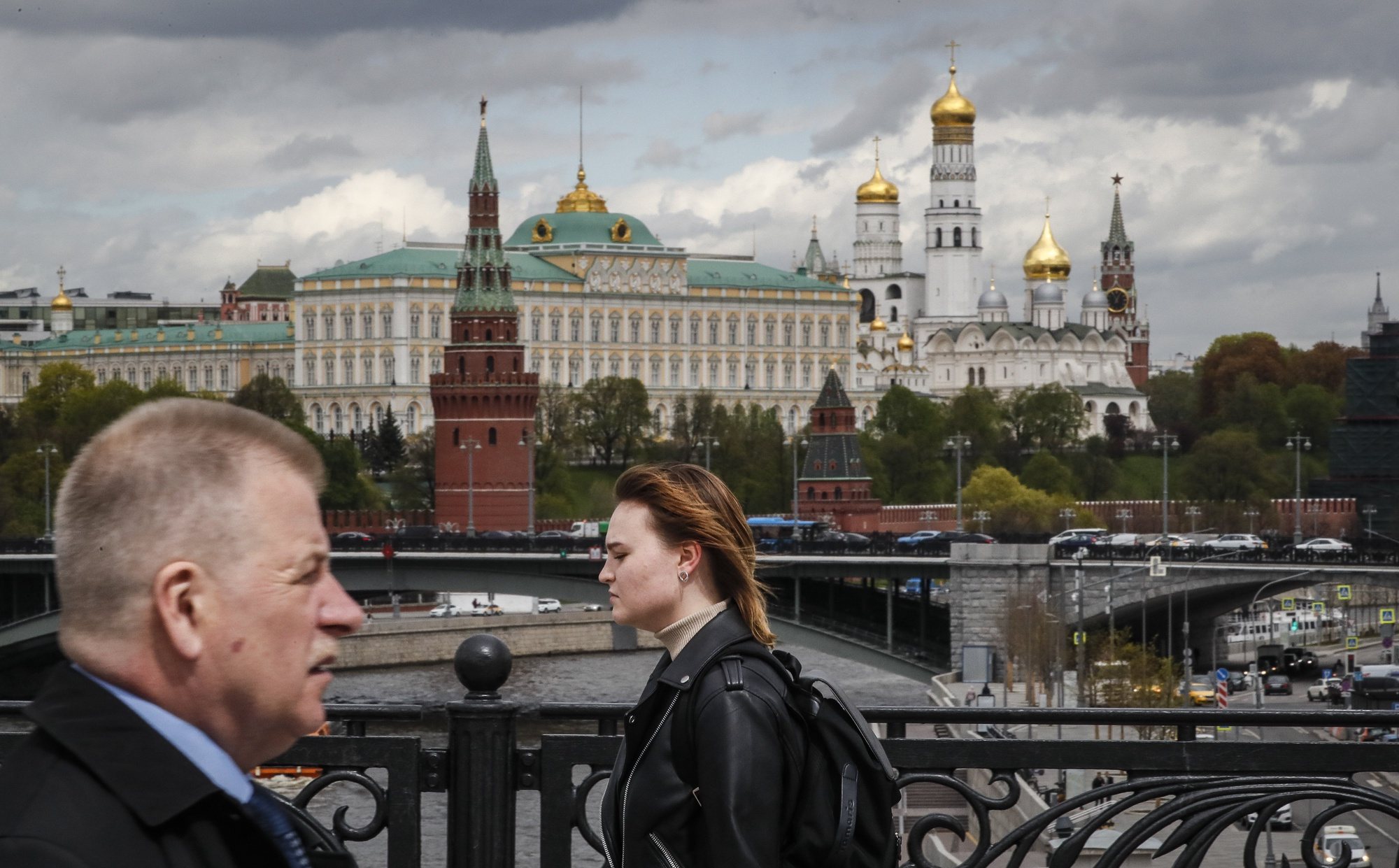epa09944773 Russian people walk in front of the Kremlin in Moscow, Russia, 13 May 2022.  EPA/YURI KOCHETKOV