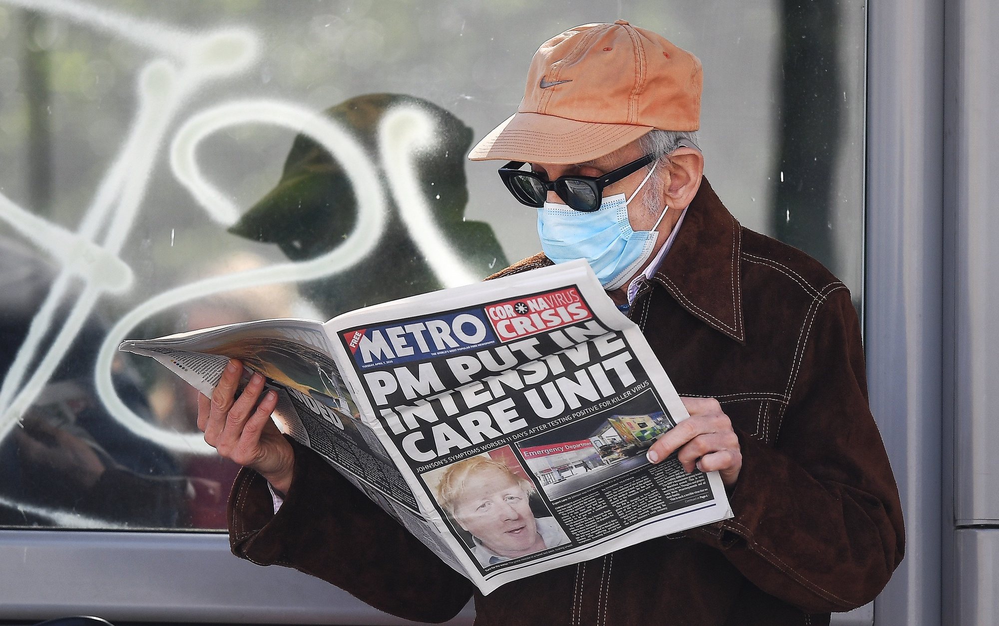 epa08347768 A man wearing a protective mask reads the news about British Prime Minister Boris Johnson&#039;s condition outside St.Thomas&#039; Hospital in London, Britain, 07 April, 2020.  According to a statement by his office, British Prime Minister Boris Johnson was admitted into St. Thomas&#039; Intensive Care Unit (ICU) on the evening of 06 April – 11 days after first having tested positive for the pandemic COVID-19 disease caused by the SARS-CoV-2 coronavirus – due to a worsening of his symptoms. First Secretary of State Dominic Raab, who also serves as Secretary of State for Foreign and Commonwealth Affairs, will be deputizing for Johnson when needed, the statement added.  EPA/ANDY RAIN