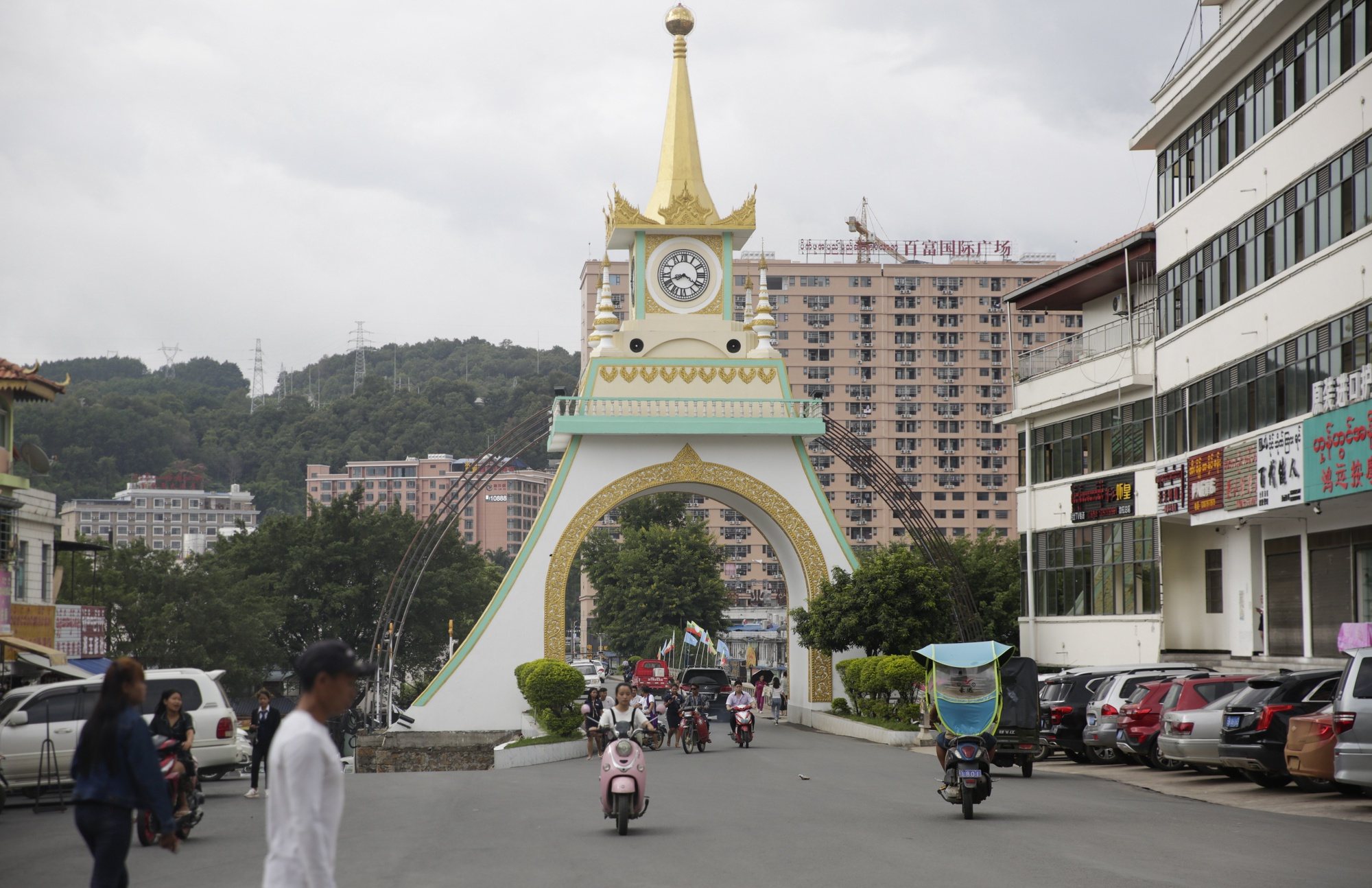 Peões e motociclitas no centro da cidade de Mong La, este de Shan Sate, Myanmar, 27 de junho de 2019