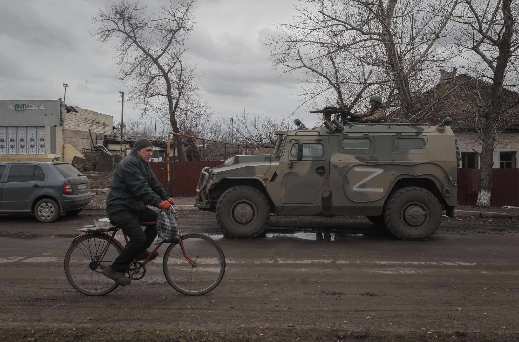 epa09853298 Local man with humanitarian aid bicycling in front of Russian army all-terrain infantry mobility vehicle ‘Tigr’ during food distribution organised by Russian army and militias of self-proclaimed LPR in village Trokhizbenka, Luhansk region, Ukraine, 27 March 2022. Chairman of the Government of the LPR Sergey Kozlov reported that as of March 22, the retreating Kyiv (Kiev) security forces had blown up 22 bridges, but the Republic would restore them. Russia will assist in the restoration and construction of infrastructure in the Republic. On 24 February Russian troops had entered Ukrainian territory in what the Russian president declared a &#039;special military operation&#039;, resulting in fighting and destruction in the country, a huge flow of refugees, and multiple sanctions against Russia. The letter Z has been used by Russian forces as an identifying sign on their vehicles in Ukraine.  EPA/SERGEI ILNITSKY