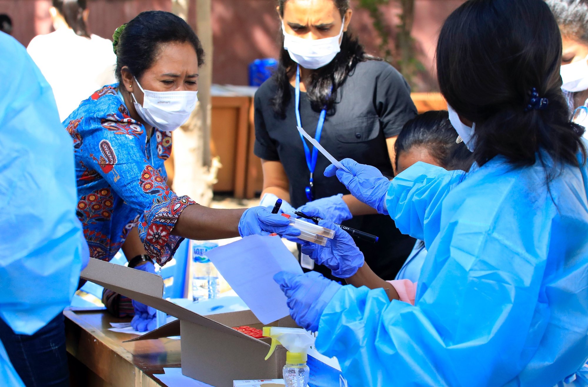 epa09368978 Health workers prepare to collect specimen samples from residents during a COVID-19 swab testing in Dili, East Timor, known also as Timor Leste, 27 July 2021. East Timor has recorded more than 10,000 coronavirus disease (COVID-19) cases since the beginning of the pandemic.  EPA/ANTONIO DASIPARU